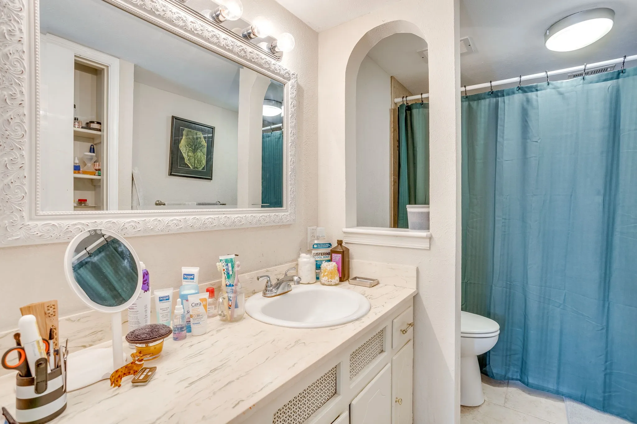 Bathroom vanity featuring an integrated sink, a light-toned countertop, and white cabinetry