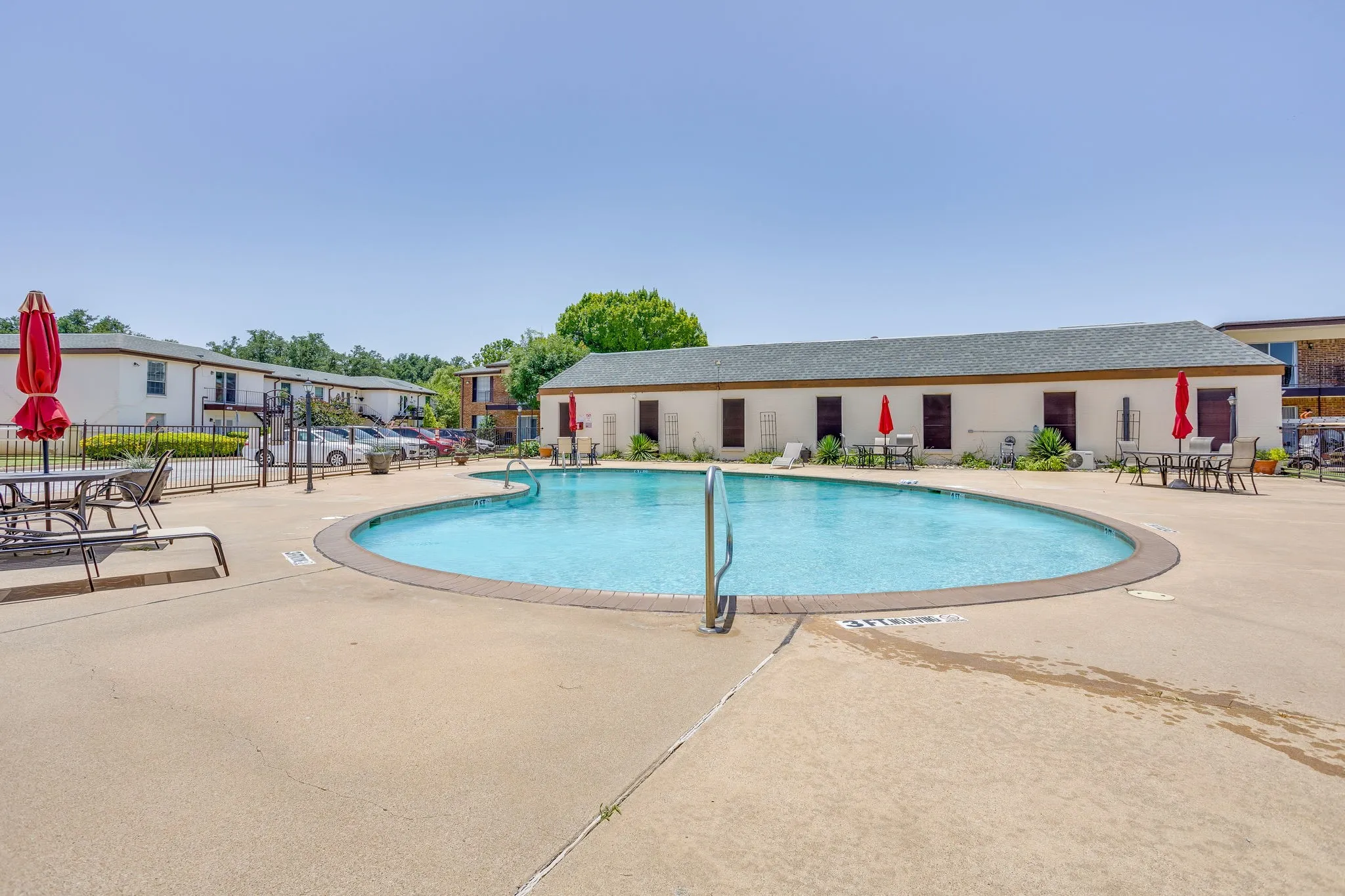 Community swimming pool with surrounding concrete decking