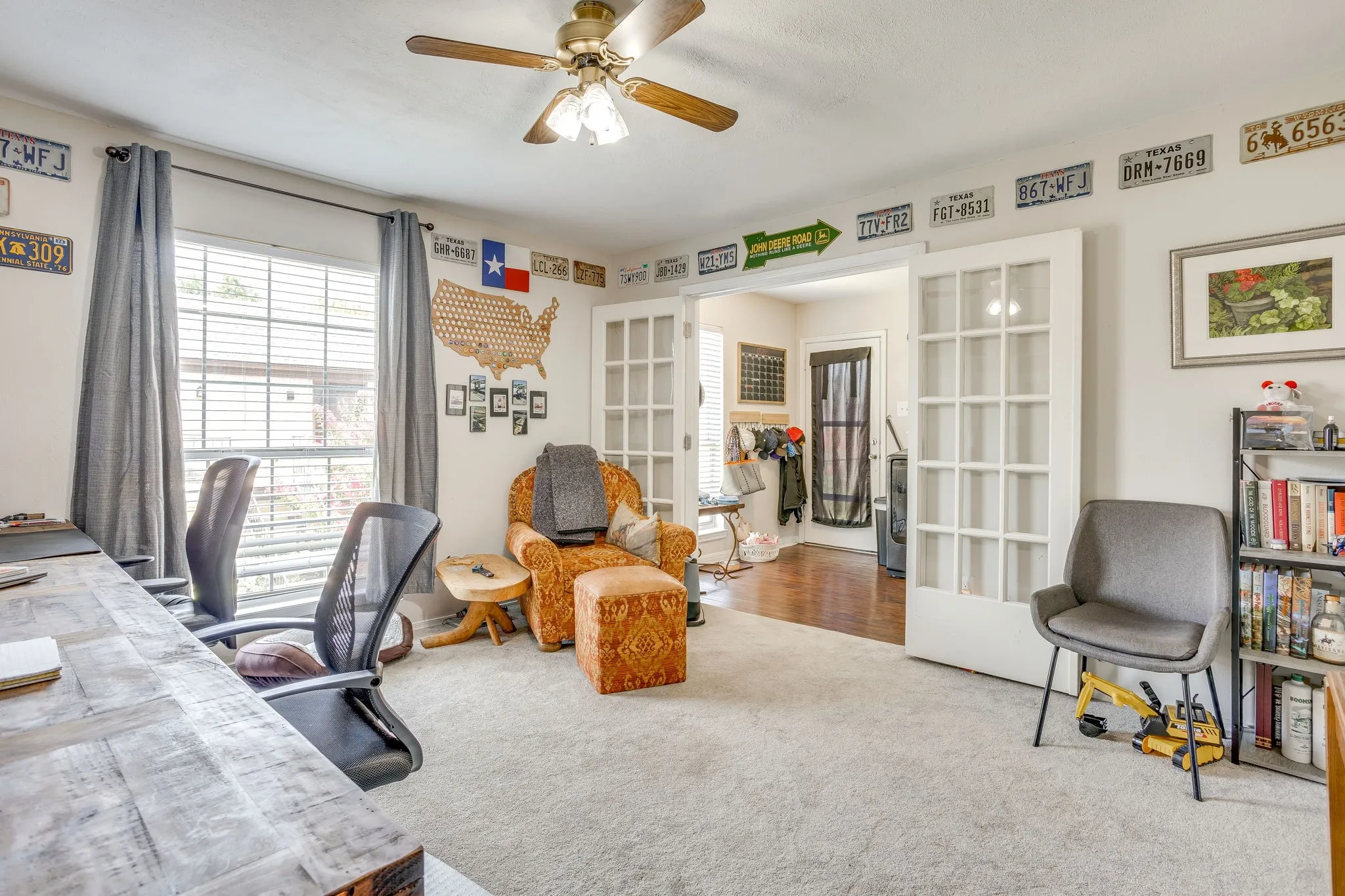 Room featuring light-toned carpeting, a window with horizontal blinds, and a ceiling fan with integrated lighting