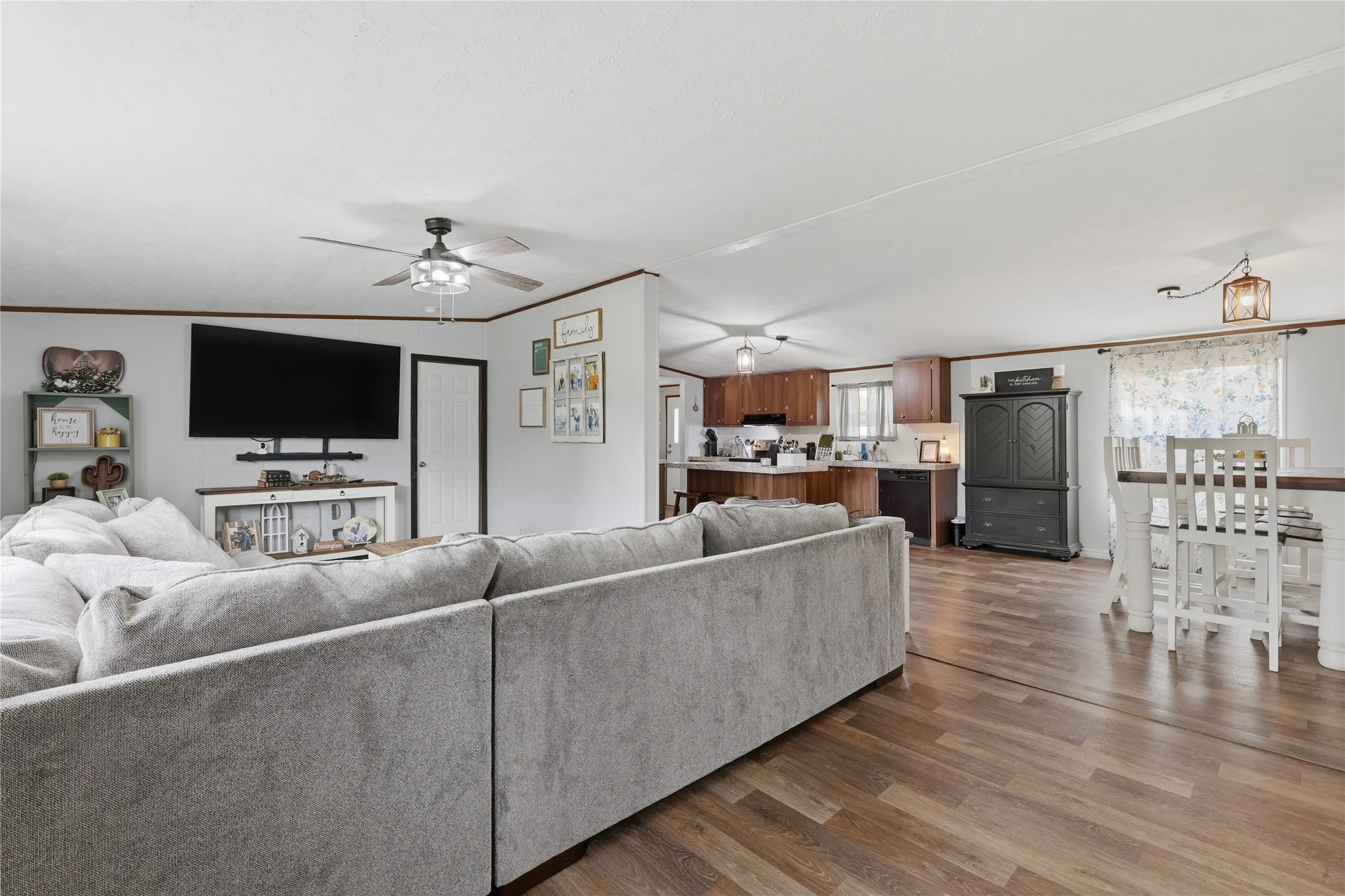 Open-concept living area featuring wood-finish flooring, a ceiling fan, and recessed lighting