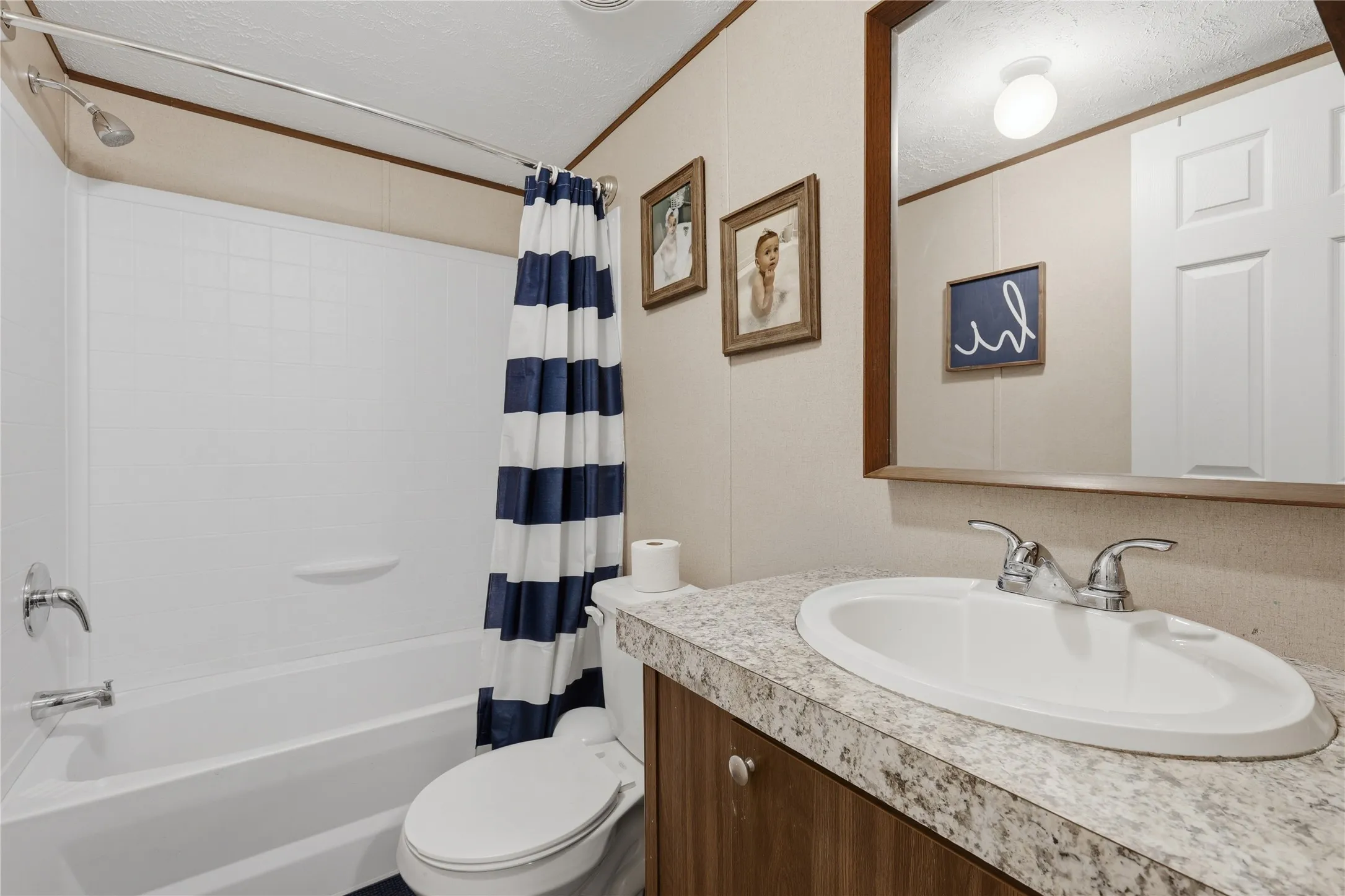 Bathroom with a tub/shower combination, chrome fixtures, and a vanity featuring an integrated sink and light-toned countertop