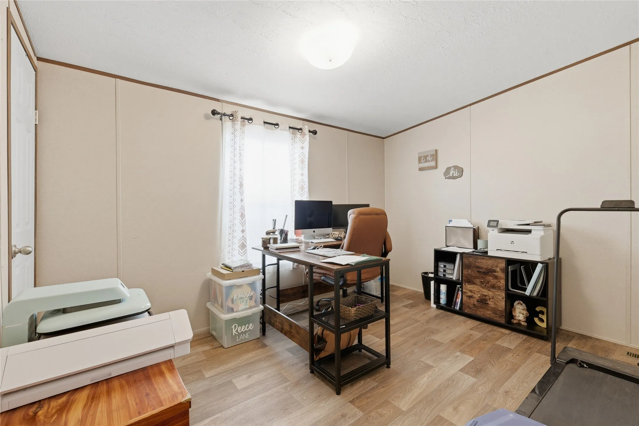 Versatile room with wood-finish flooring and a ceiling-mounted light fixture