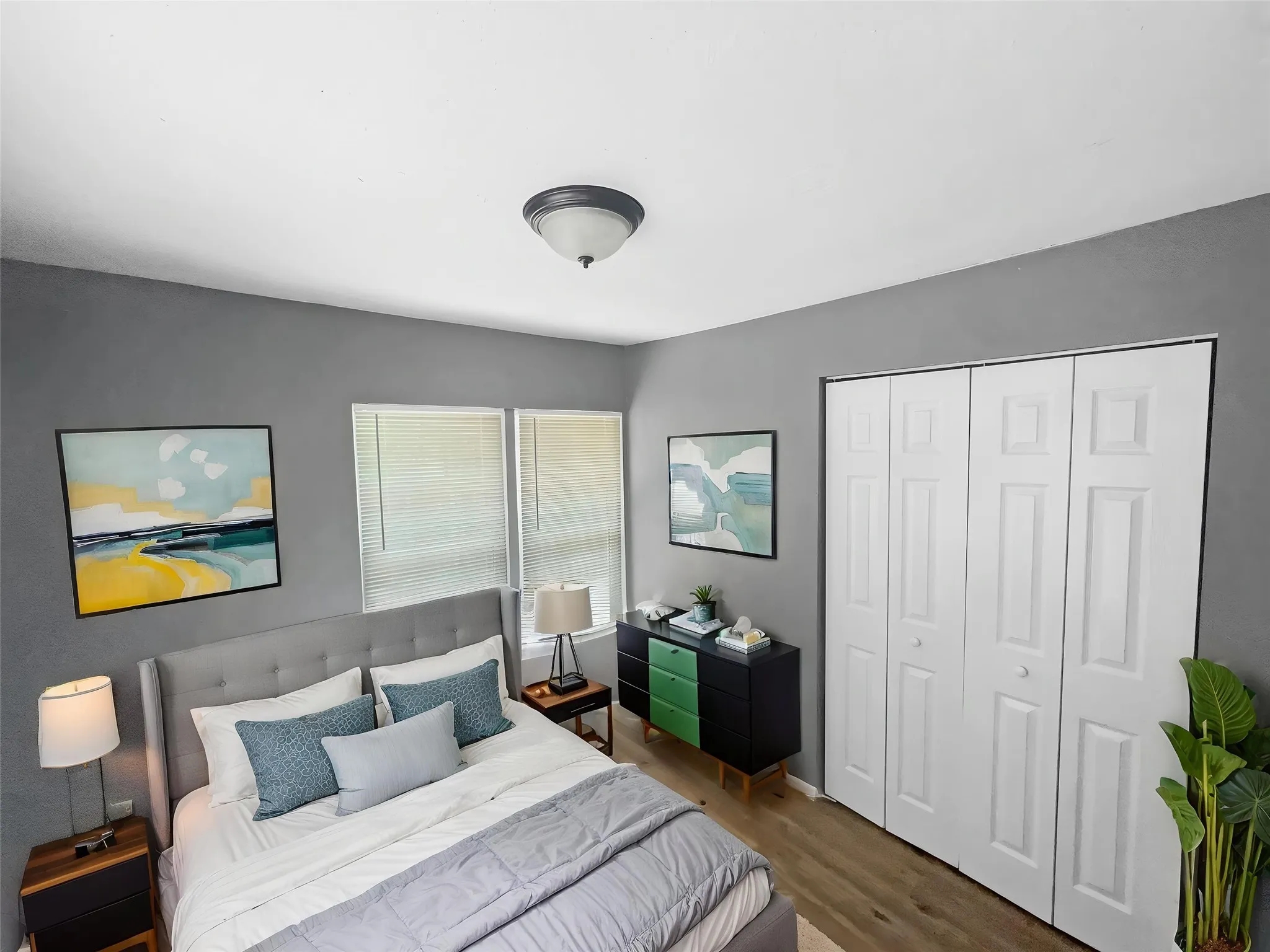 Virtually staged
Sleeping area with light gray walls and wood-finish flooring