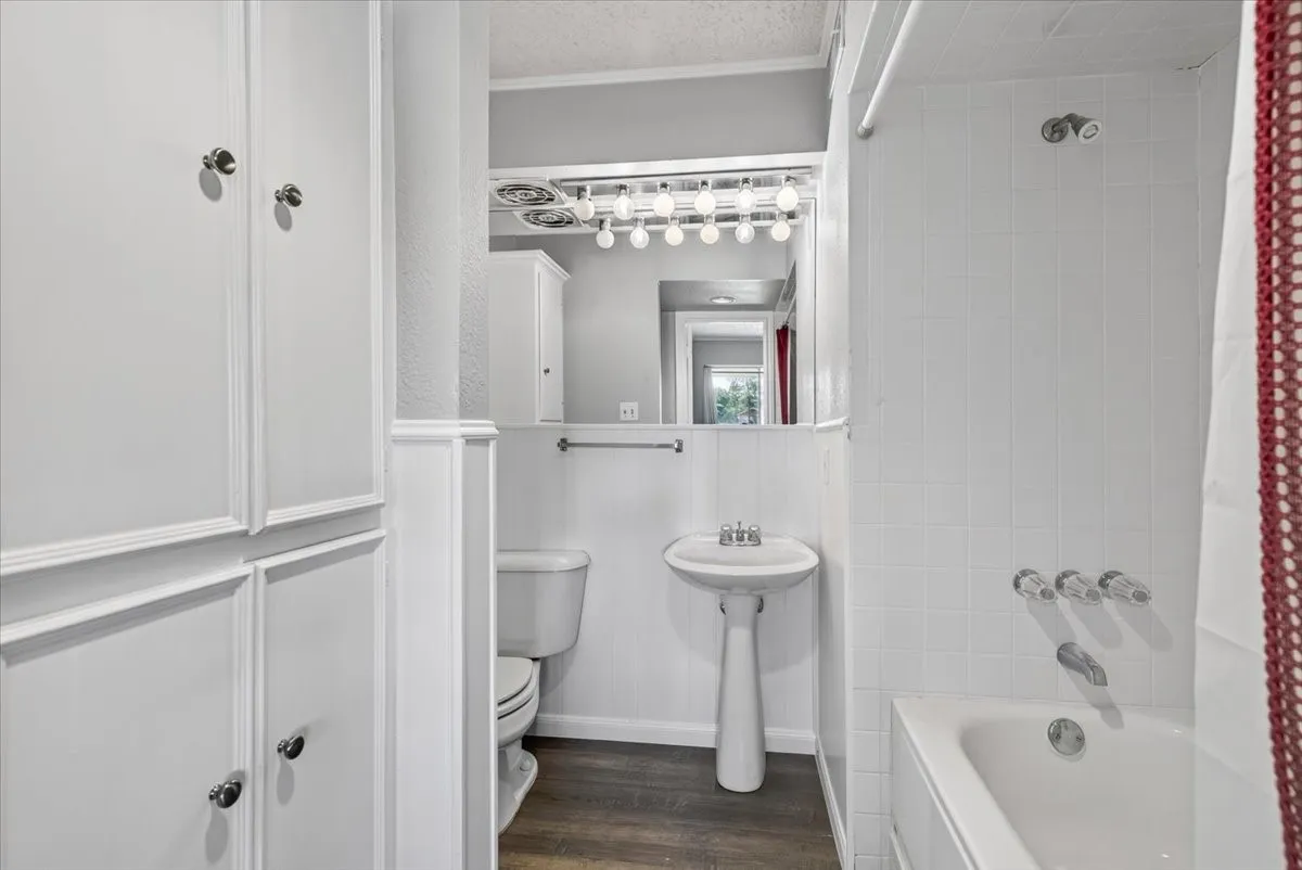 #3 Primary Bathroom with storage, pedestal sink and tub shower combo