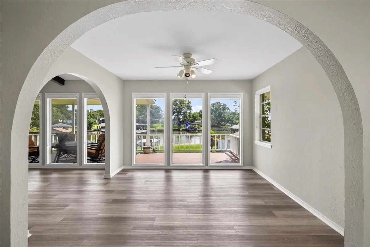 Lakeside Open dining room view from kitchen and open to Main Living area through Arch on left, tons of natural light through floor to ceiling windows facing lake side deck