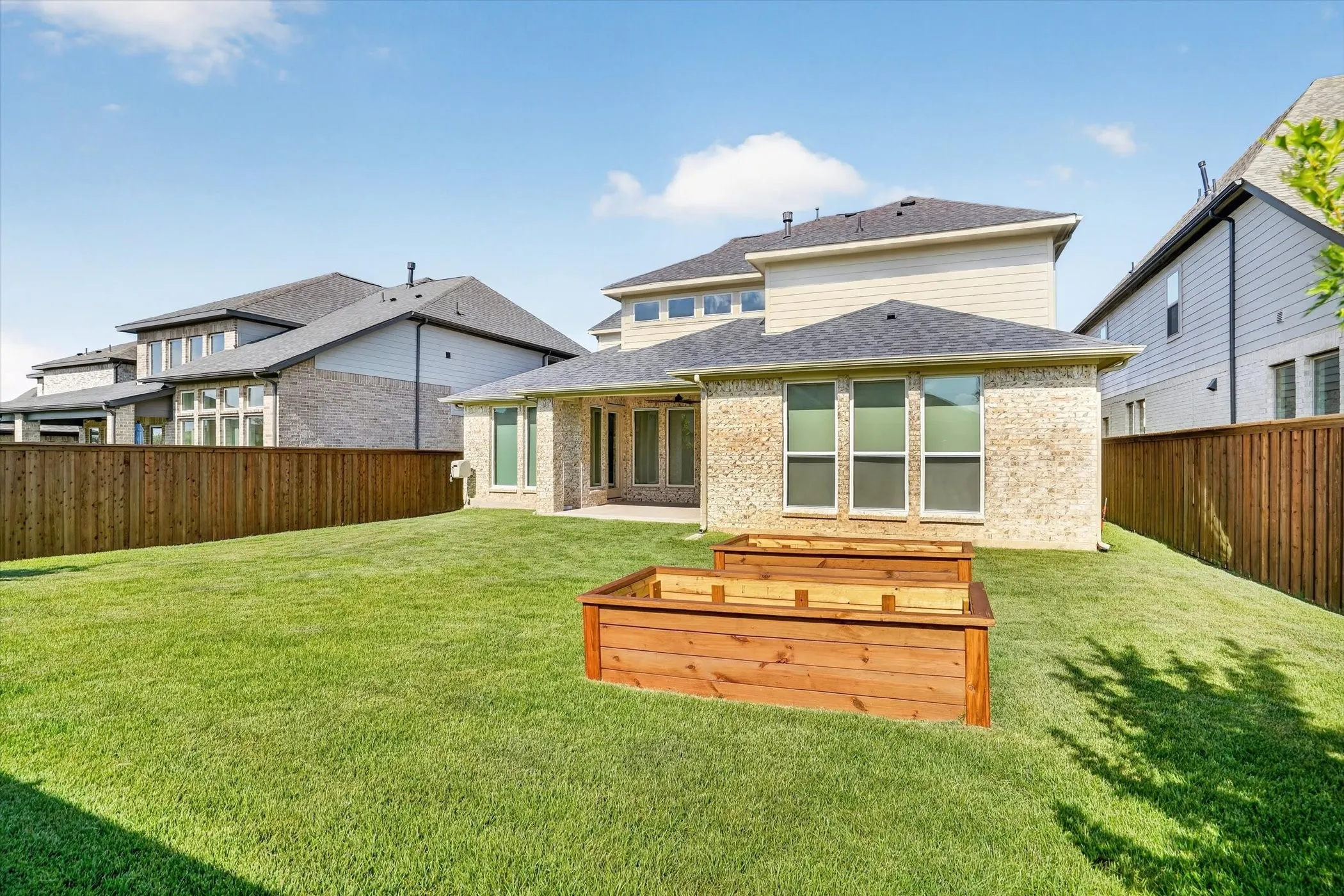 Expansive green lawn featuring two tiered raised garden beds