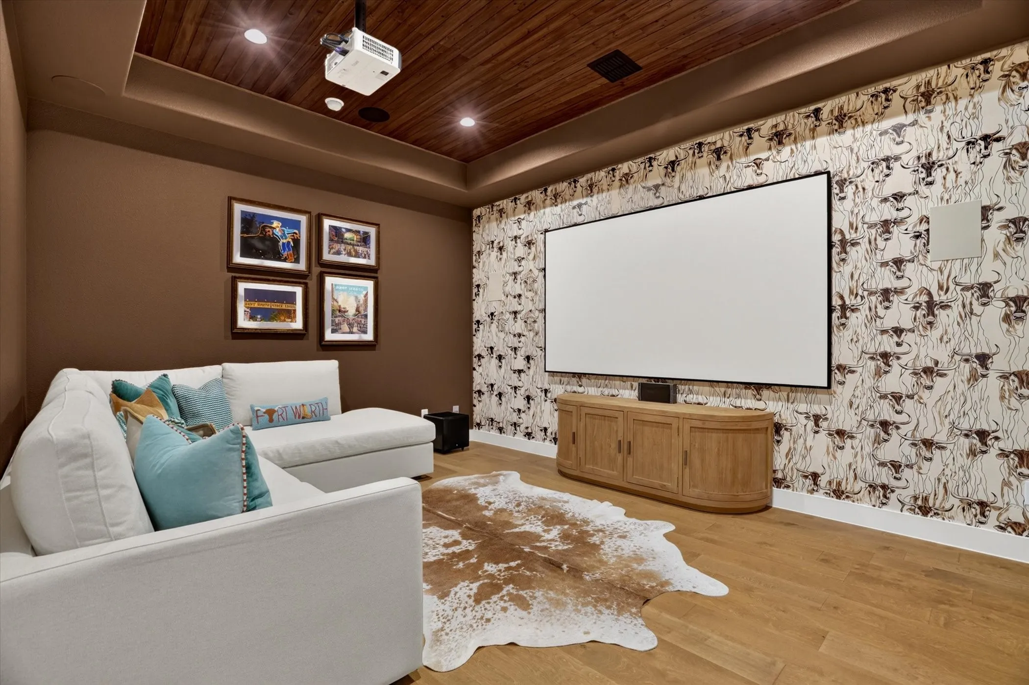 Dedicated media room featuring wood-finish flooring, a projector system, built-in screen, and a rich wood plank ceiling