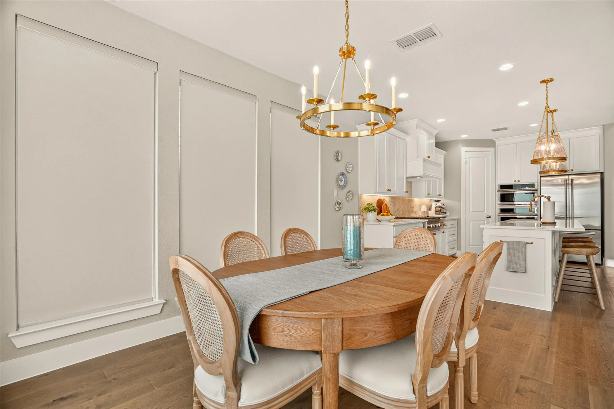 Dining area featuring a gold-finish chandelier, wood-finish flooring, and panel molding