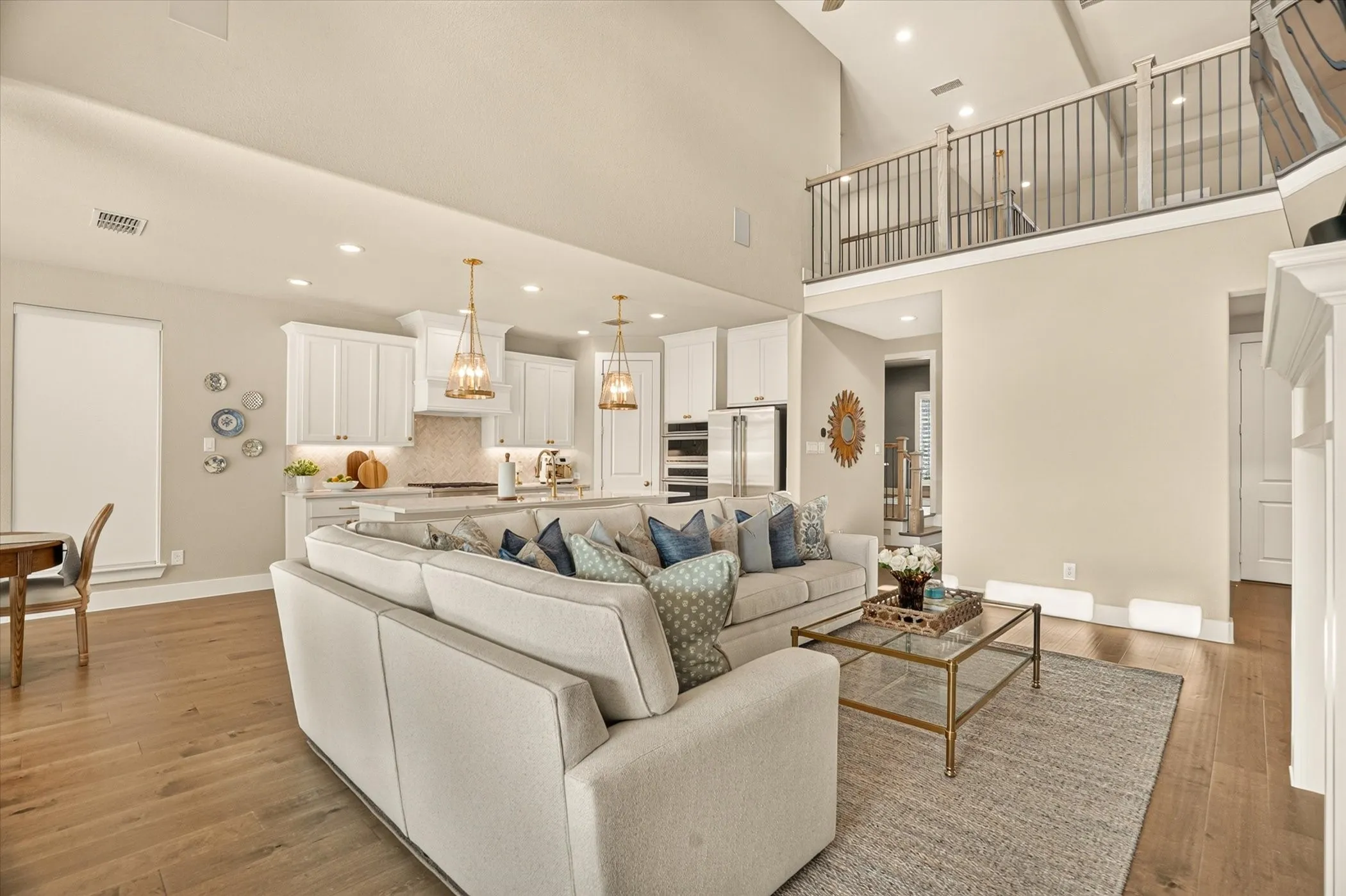 Open-concept living space with a soaring ceiling and wood-finish flooring