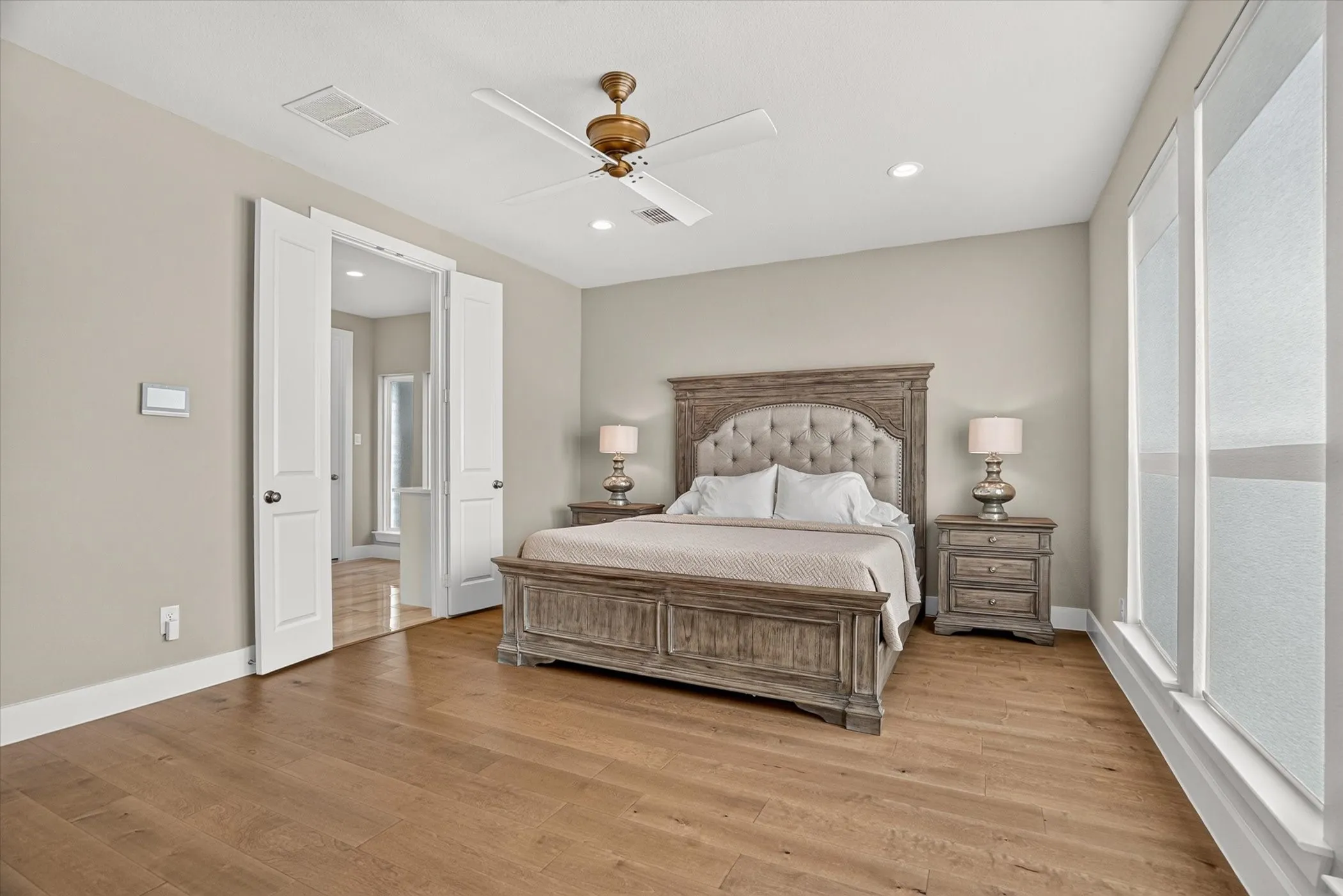 Spacious room featuring wood-finish flooring, recessed lighting, and a ceiling fan