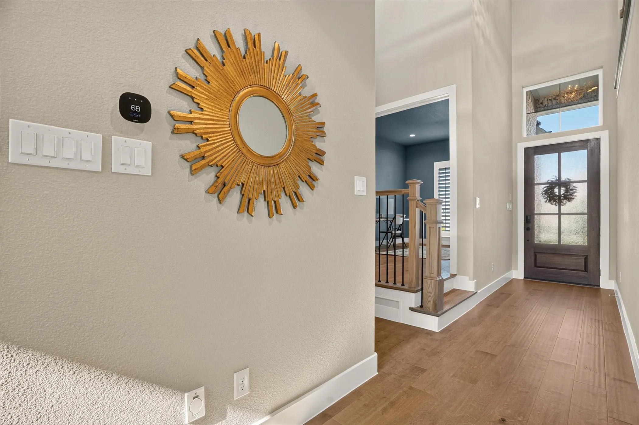 Entryway featuring wood-finish flooring, a dark wood-finish front door with frosted glass panels, and a transom window above