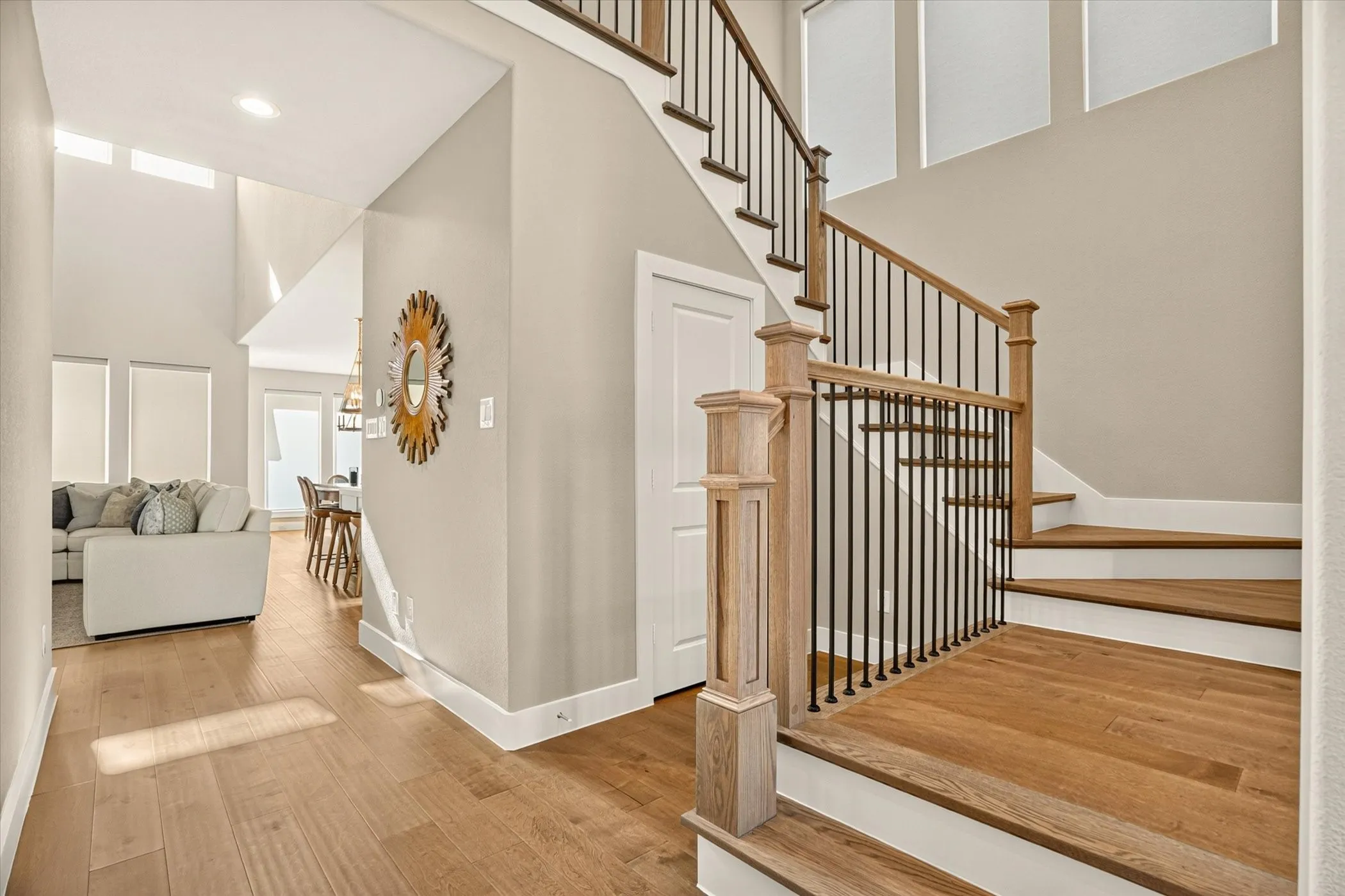 Staircase featuring wood-finish treads and risers, black metal balusters, and a wood-finish handrail