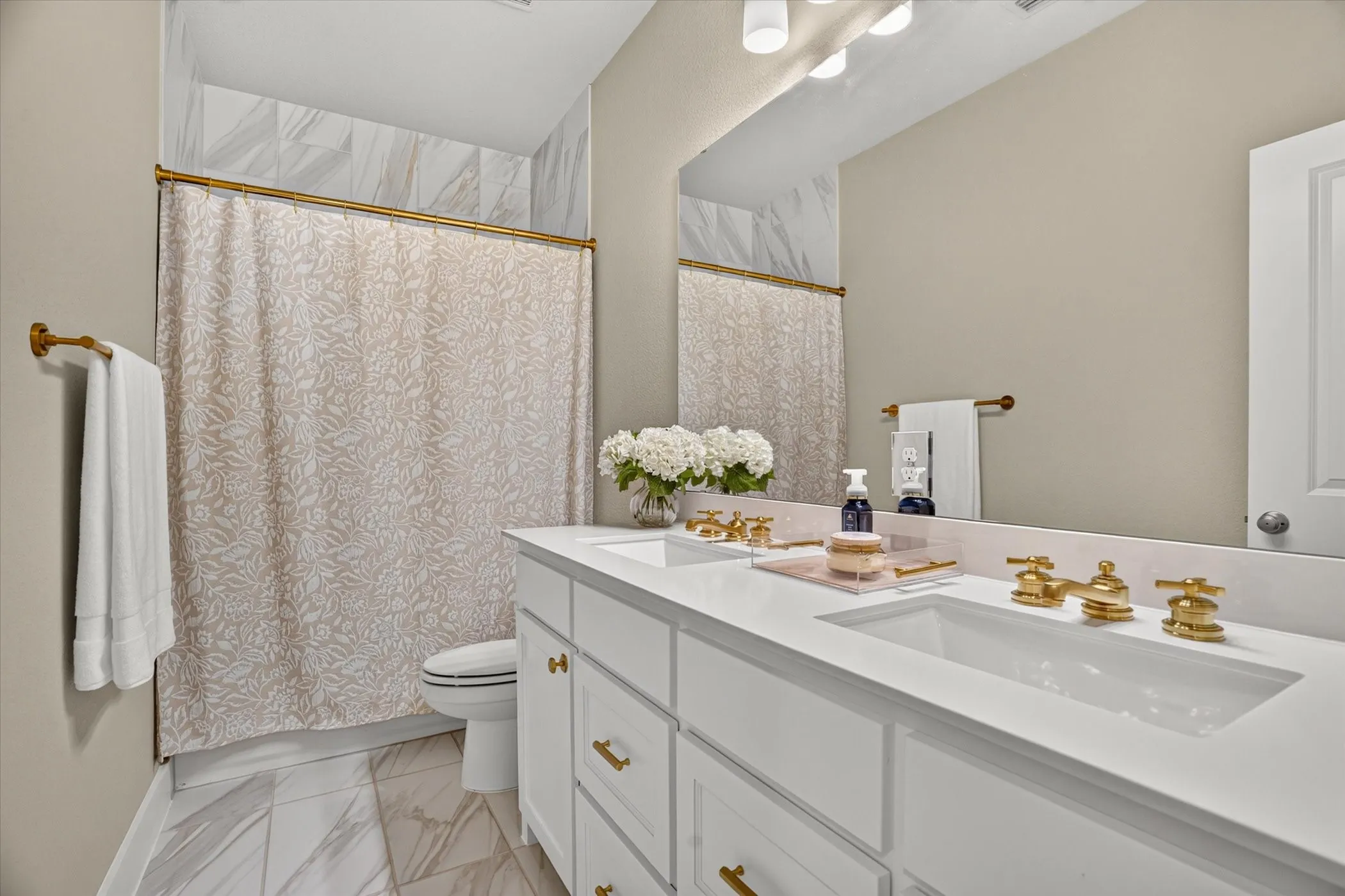 Bathroom featuring a double vanity with white cabinetry and integrated sinks