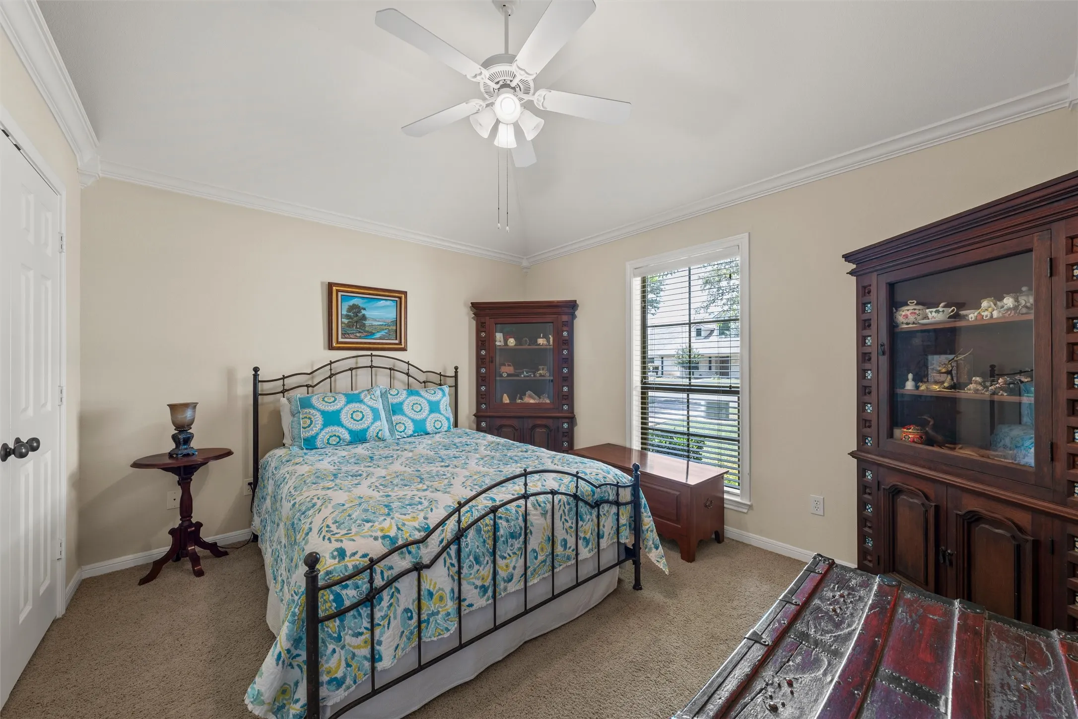 Carpeted room featuring crown molding, a ceiling fan, a window with blinds, and neutral-toned walls