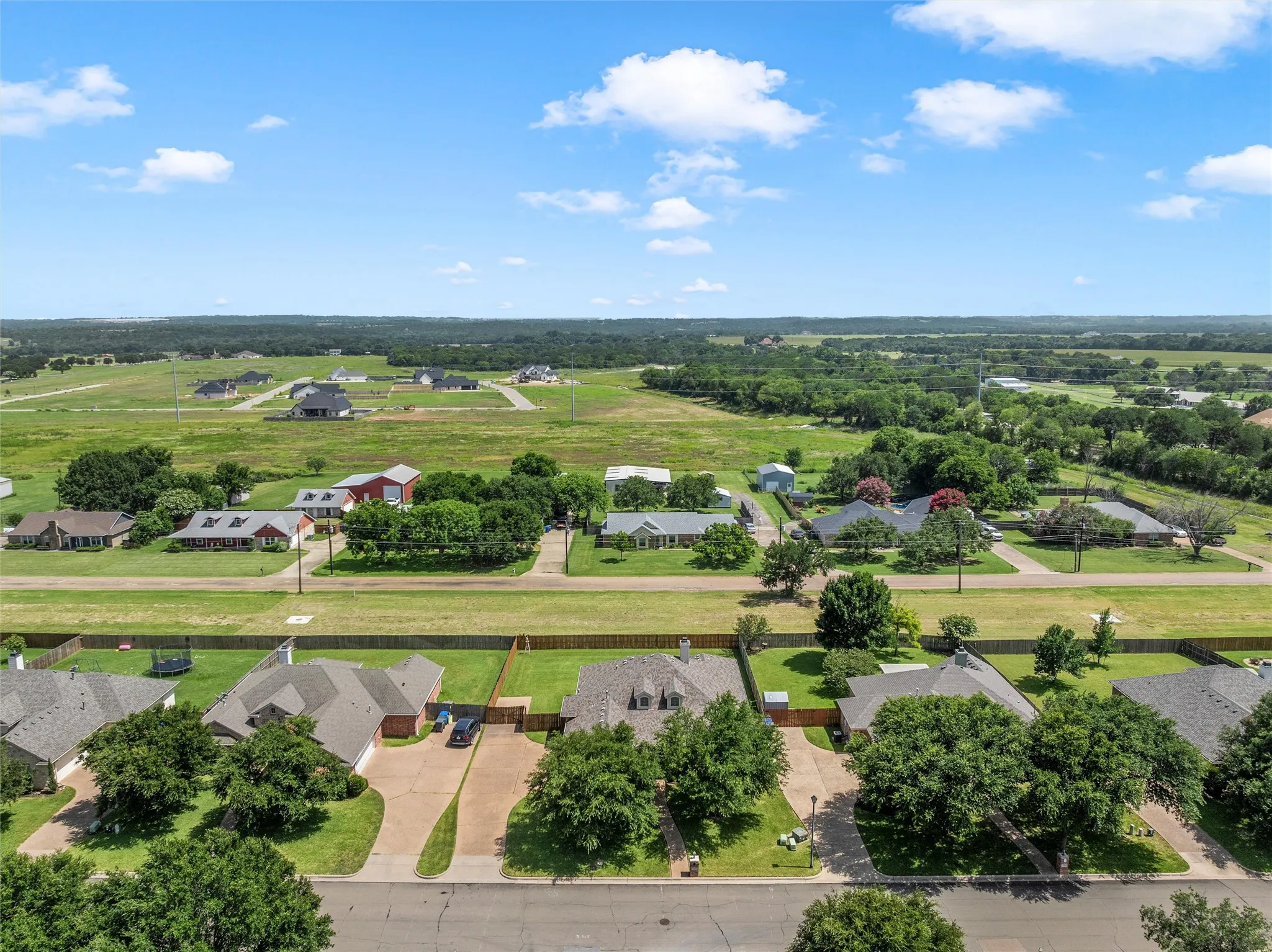 Aerial perspective showcasing a residential street with mature trees and paved driveways