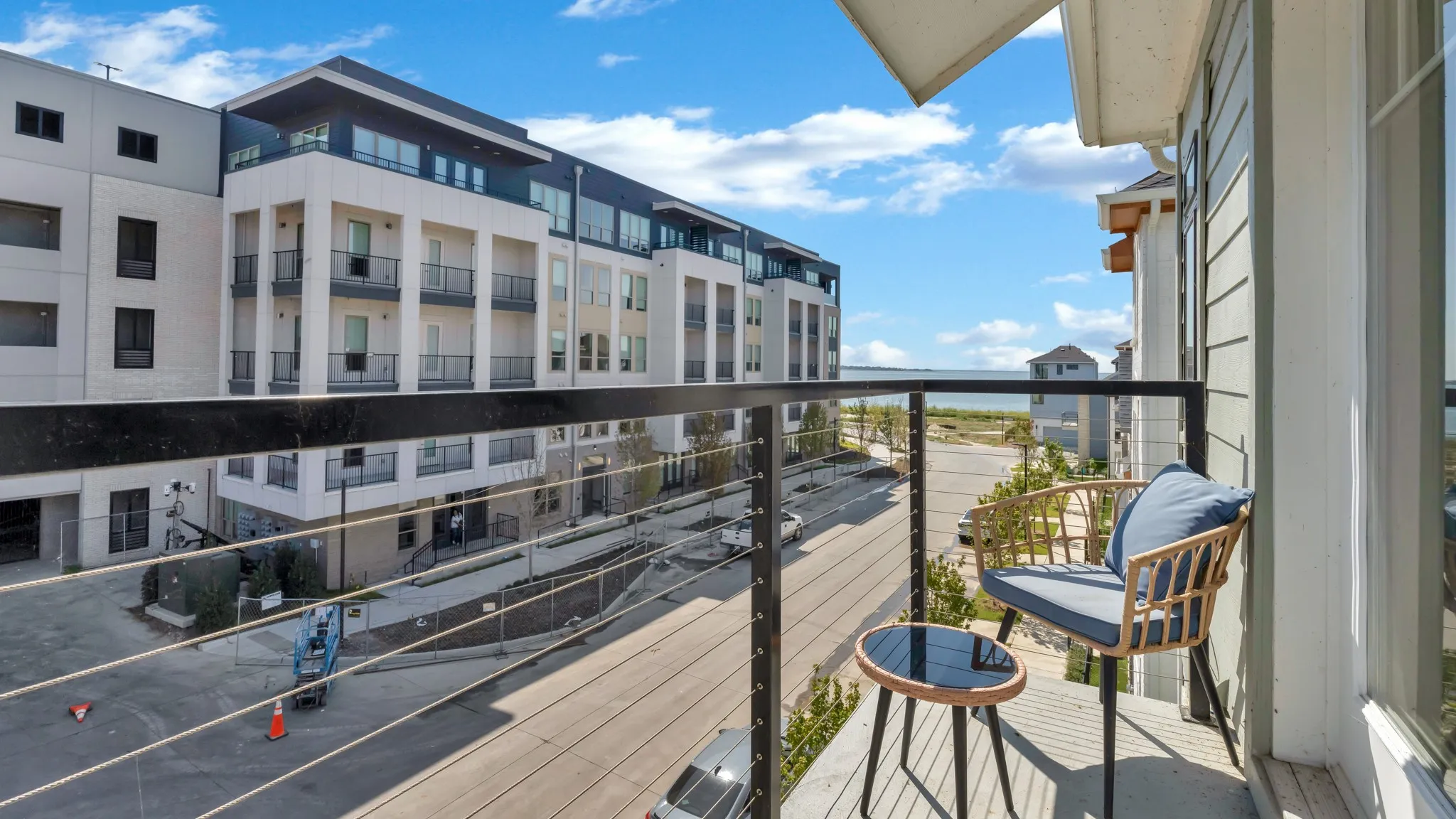 Private balcony featuring cable railings and water scenery