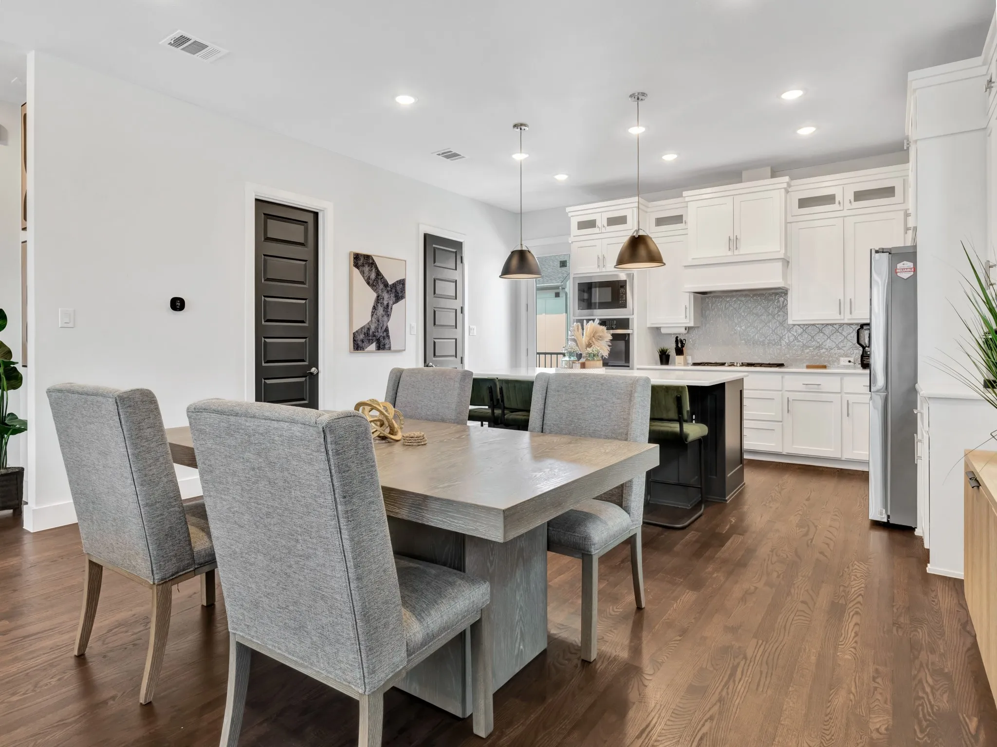 Open-concept dining area featuring wood-finish flooring, recessed lighting.