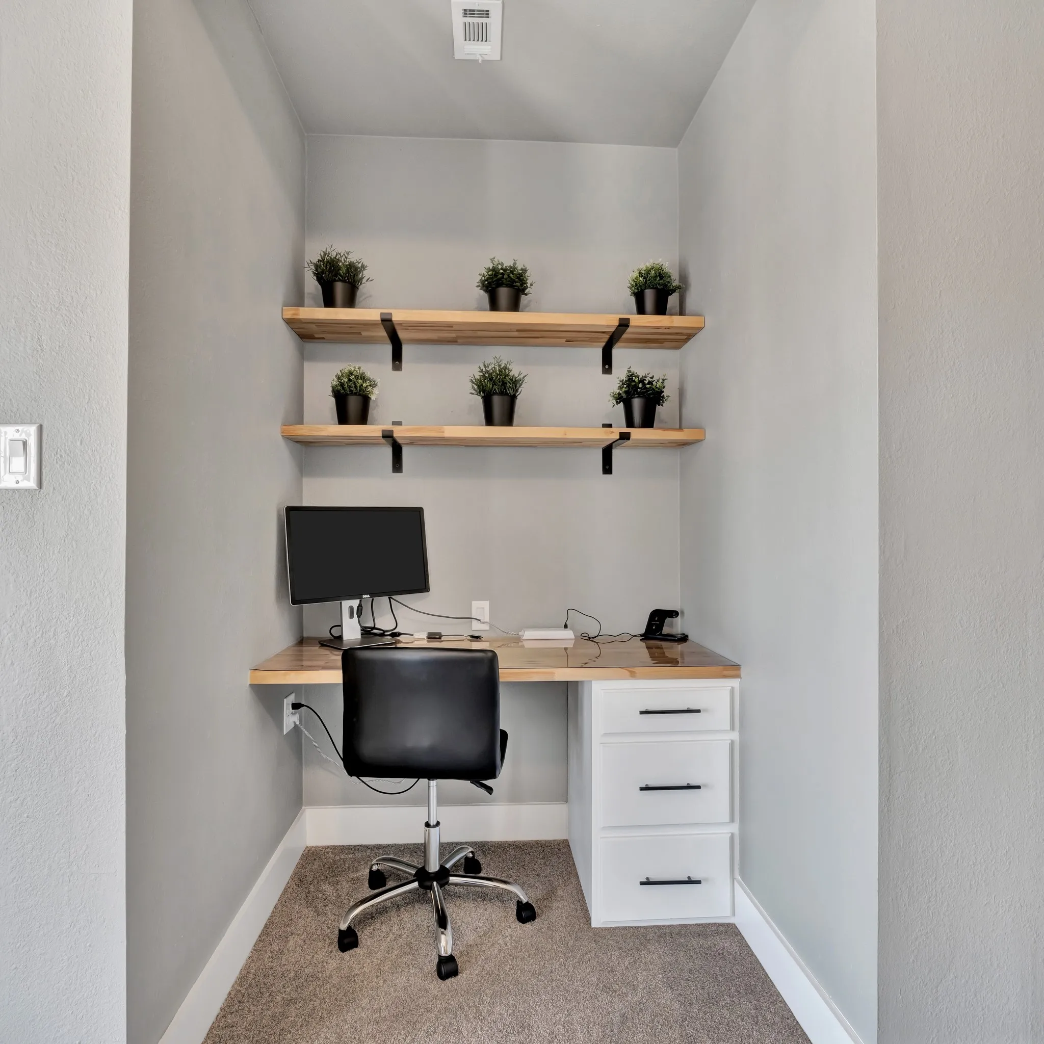 Dedicated workspace featuring a built-in wood-finish desk and white drawer unit