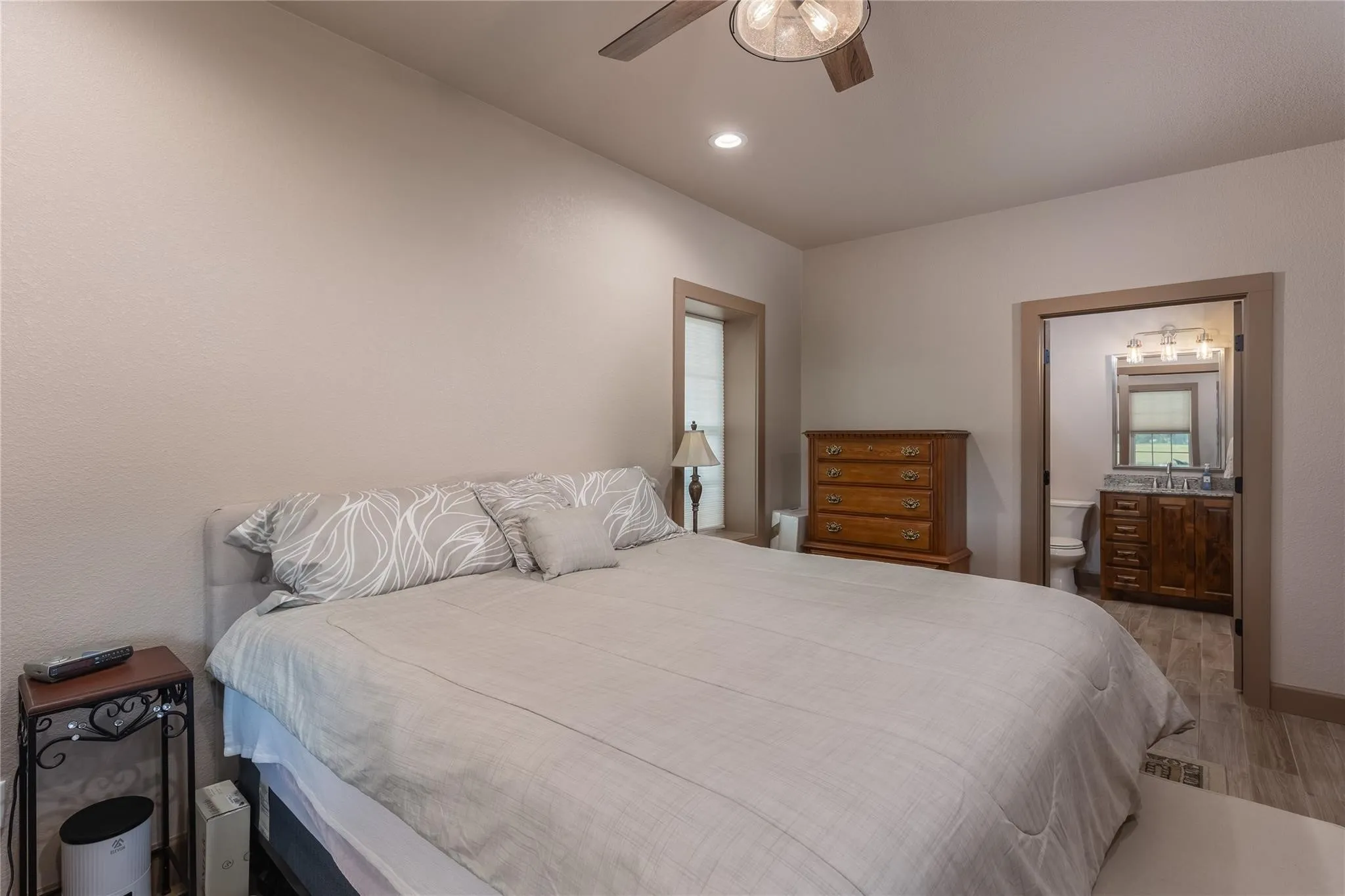 Bright bedroom with neutral wall tones and recessed lighting
