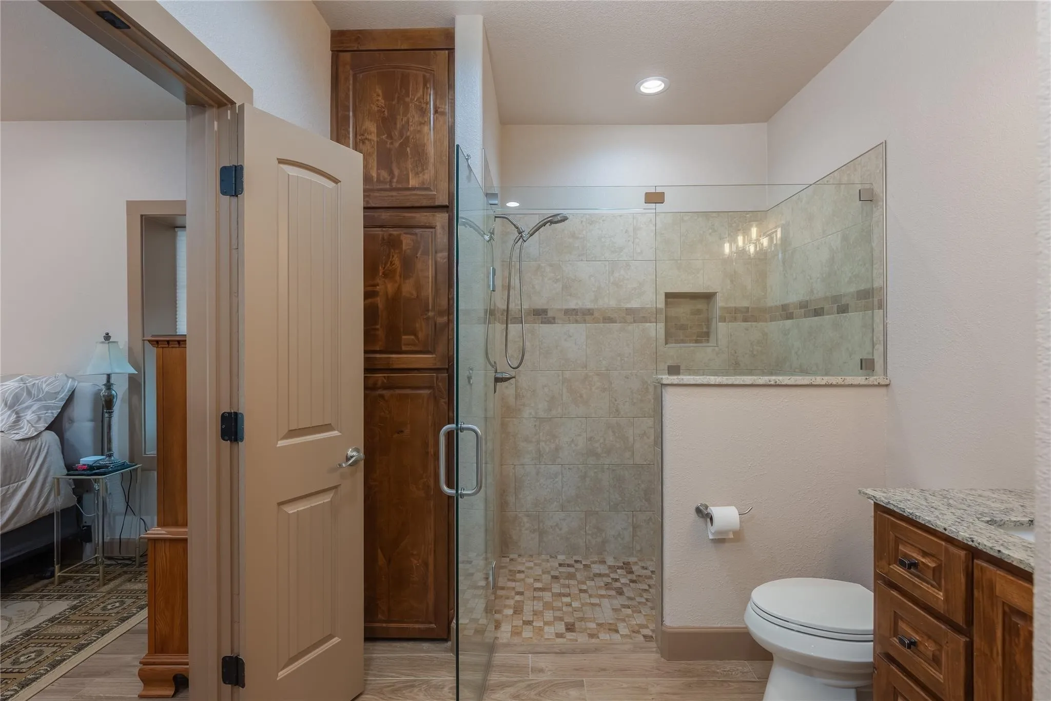 Walk-in shower with clear glass enclosure, tiled walls, and built-in niche