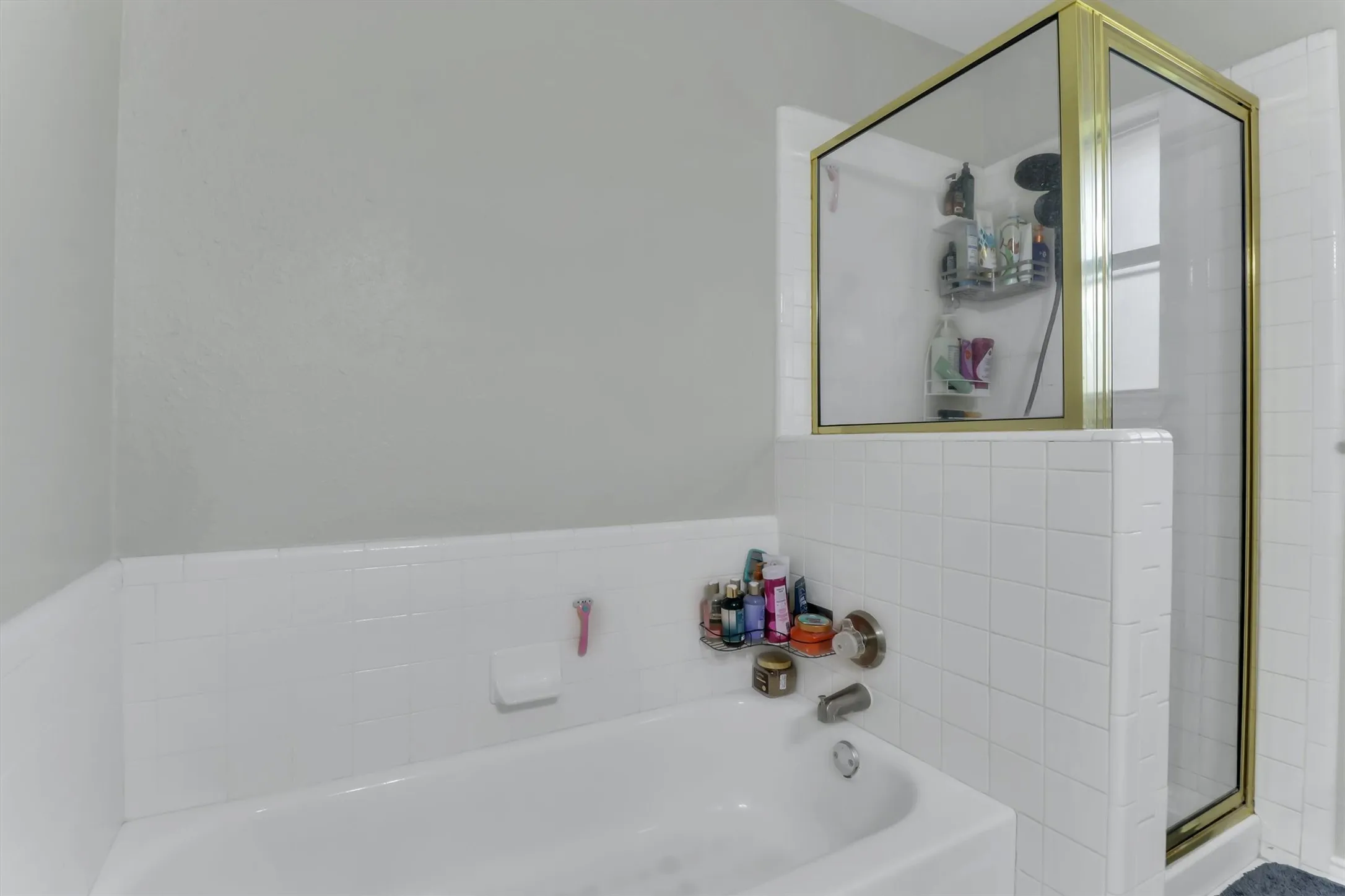 Bathtub with white subway tile surround and brushed nickel fixtures