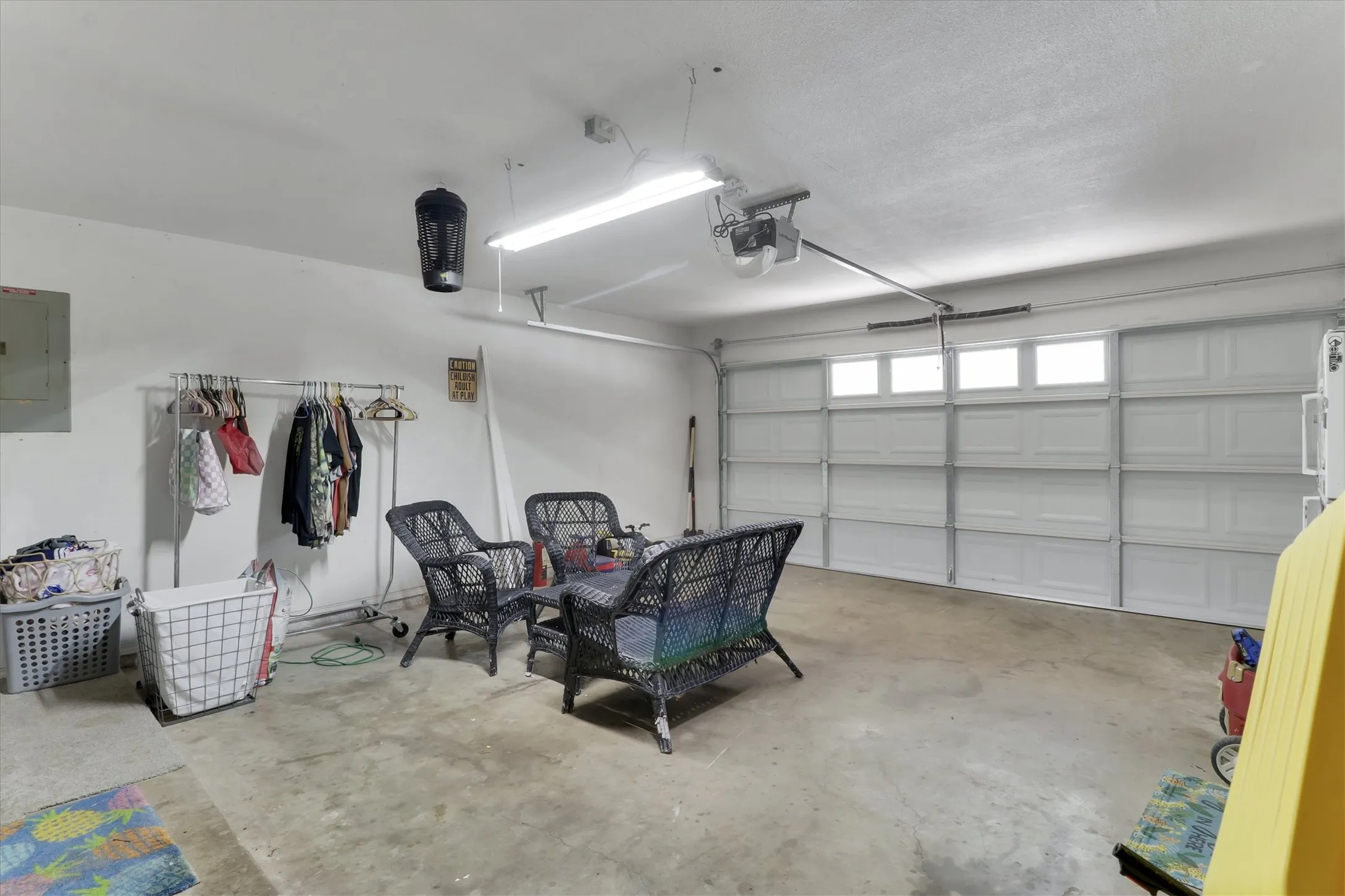 Attached garage with a panel-style door, upper window inserts, and a garage door opener