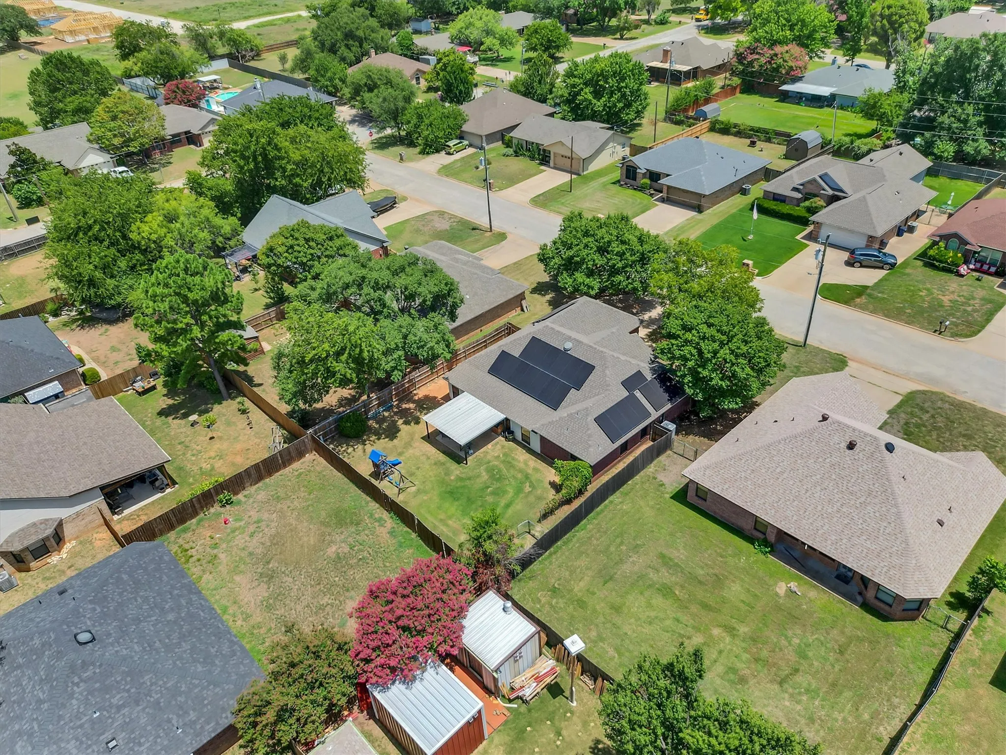 Aerial perspective of a neighborhood with residential properties and established trees