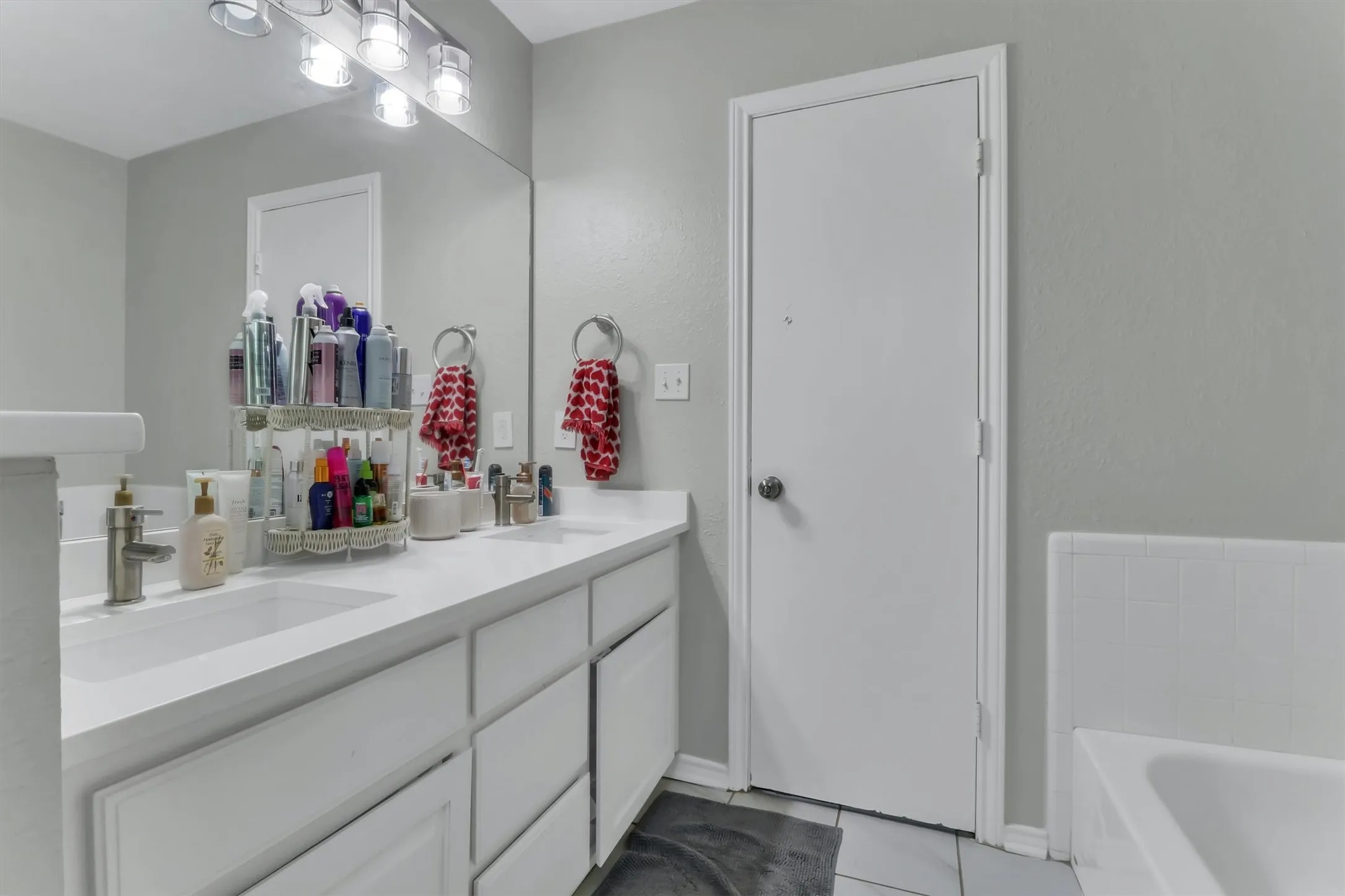 Double vanity with integrated sinks, brushed nickel faucets, and under-sink cabinetry