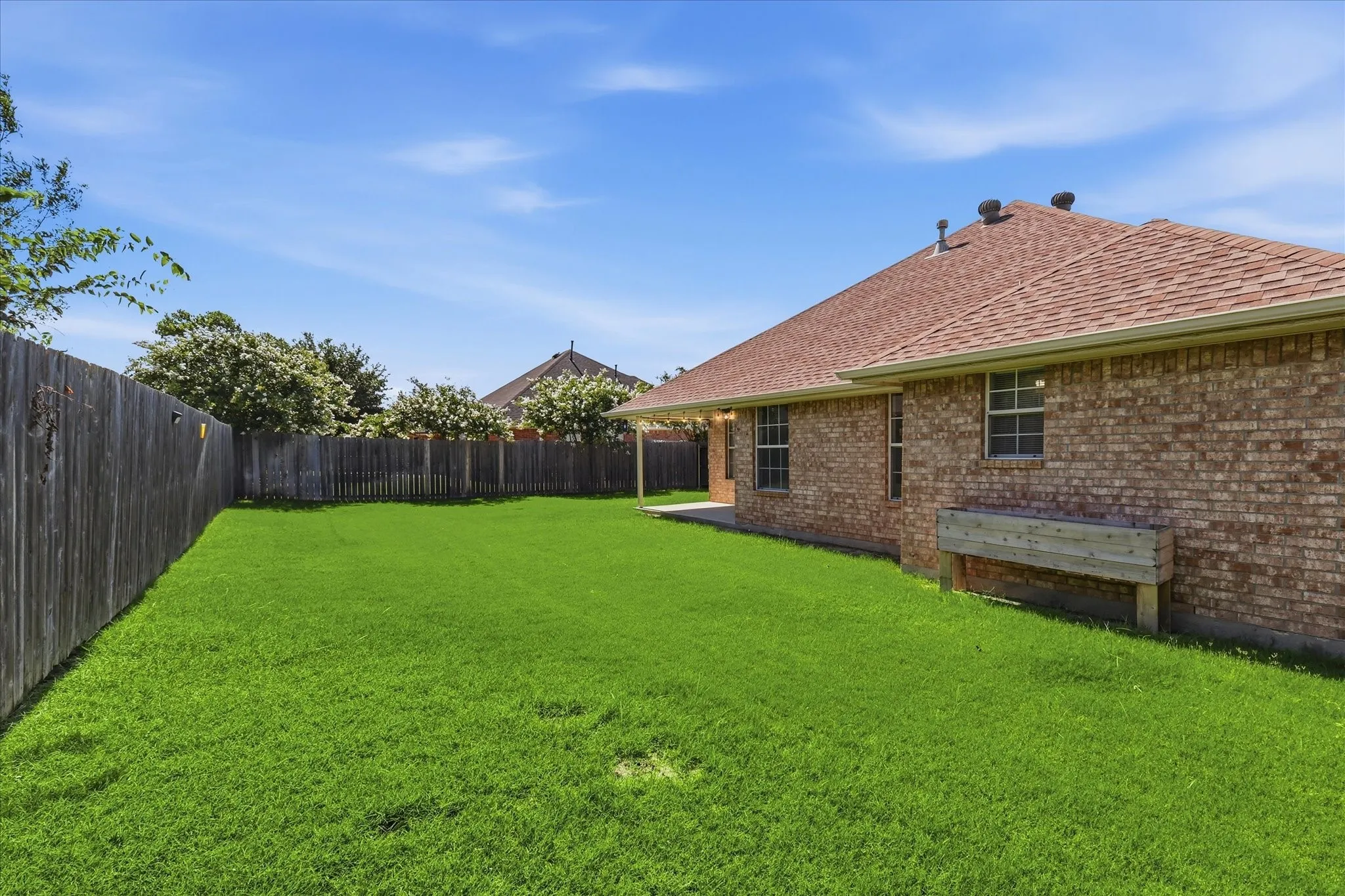 Spacious backyard featuring a lush lawn and perimeter fencing