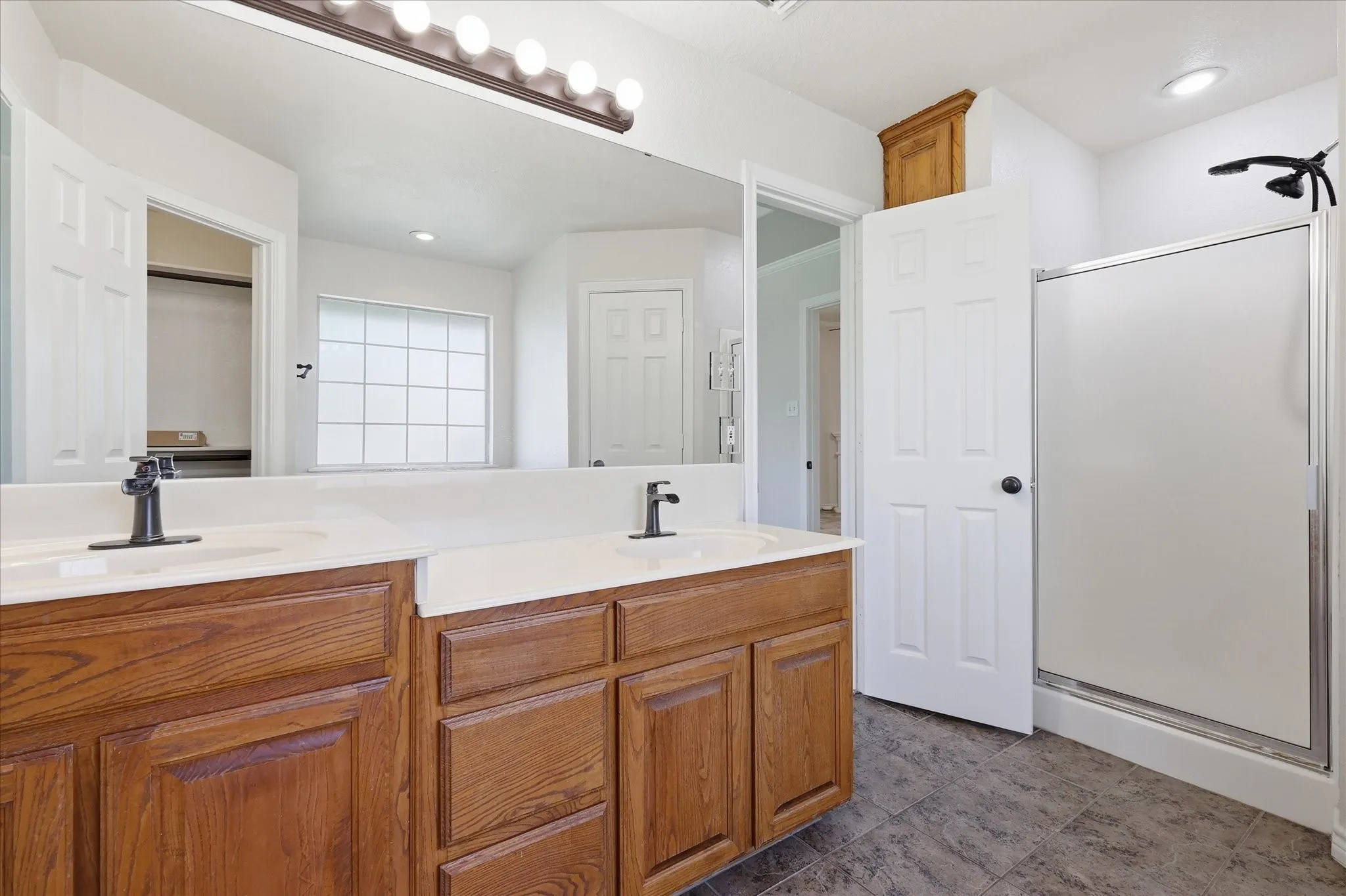 Double vanity with wood-finish cabinetry and light-toned countertops