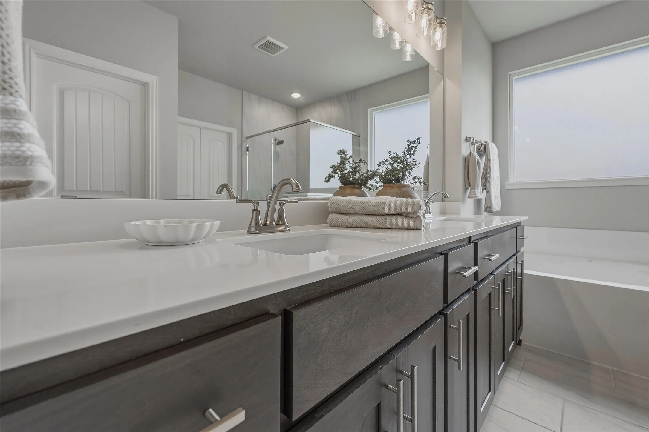 Dual vanity with a light-toned countertop, under-mount sinks, and brushed nickel faucets