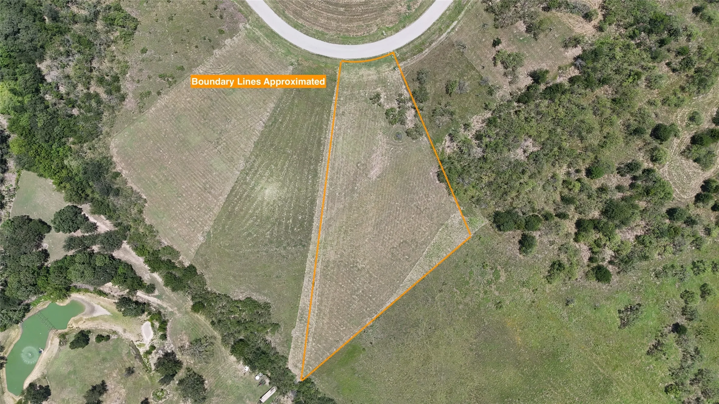 Bird's-eye view highlights the lot shape, size, and surrounding natural landscape.