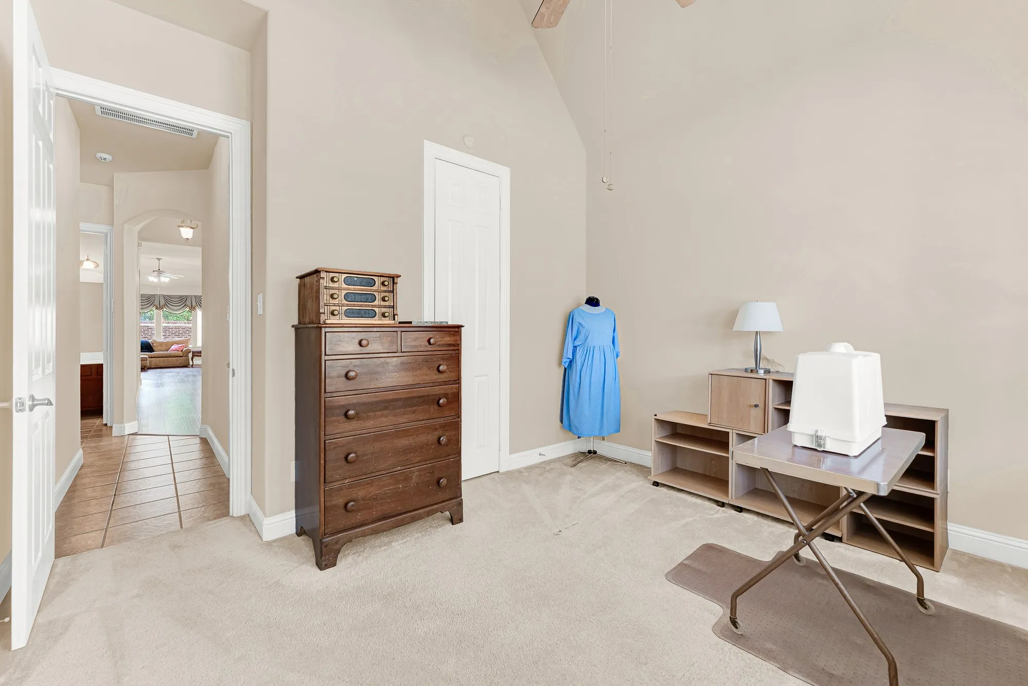 Another view of the versatile secondary bedroom showcasing the generous layout, high ceilings, large closet, and easy access to the nearby full bath.