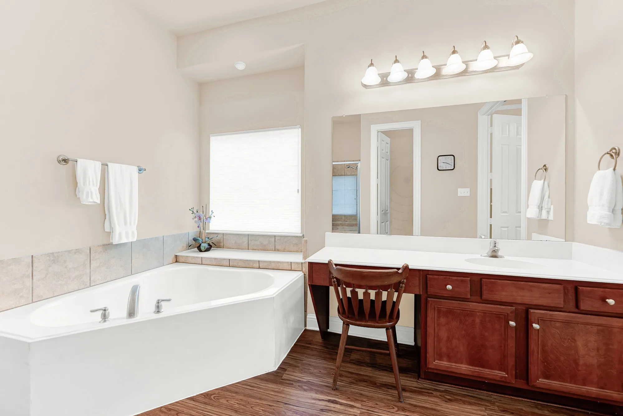 Unwind in the oversized corner soaking tub while enjoying the convenience of a built-in seated vanity, generous counter space, and abundant cabinetry.