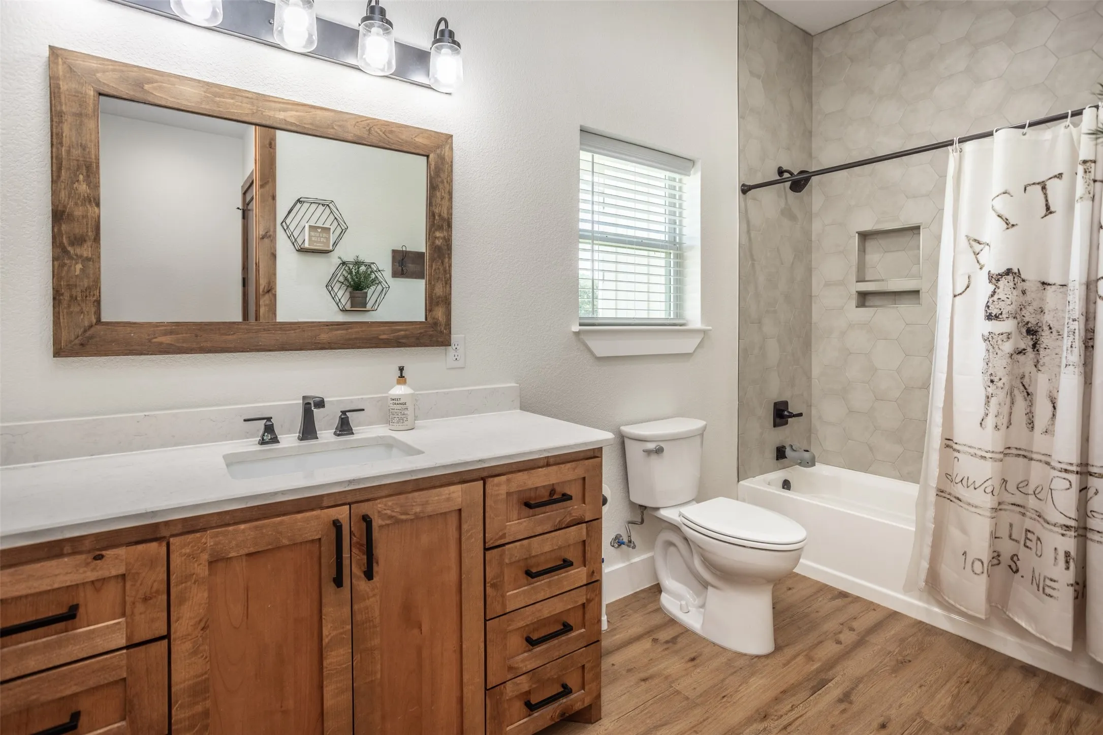 Full guest bath with tub and floor to ceiling tiled shower