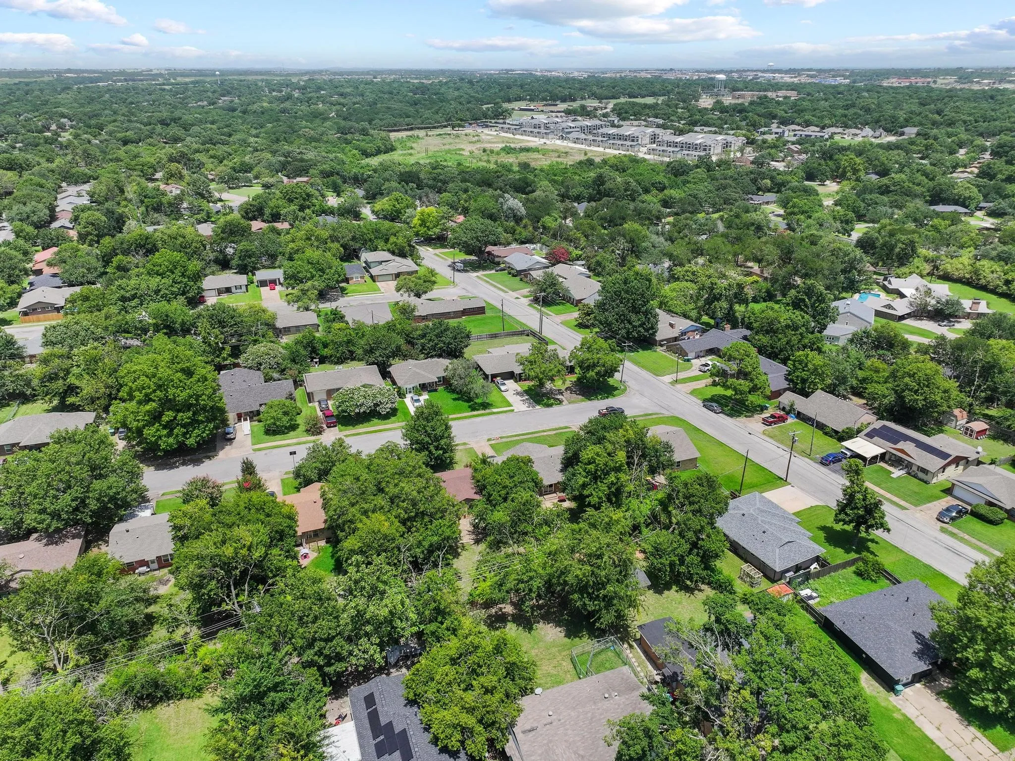 Aerial perspective showcasing a residential neighborhood with extensive mature tree coverage