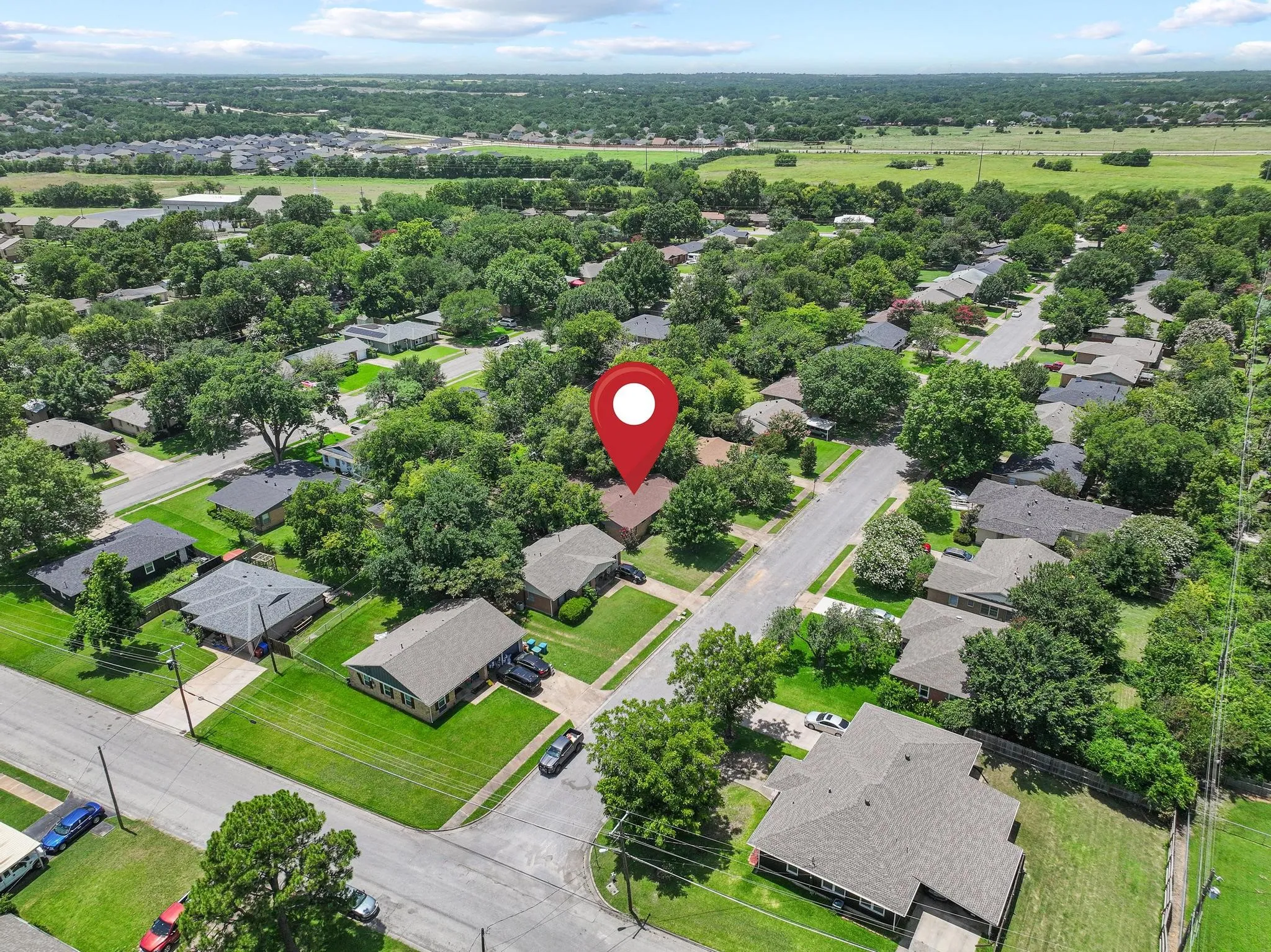 Aerial perspective showcasing residential properties with mature tree coverage and manicured lawns