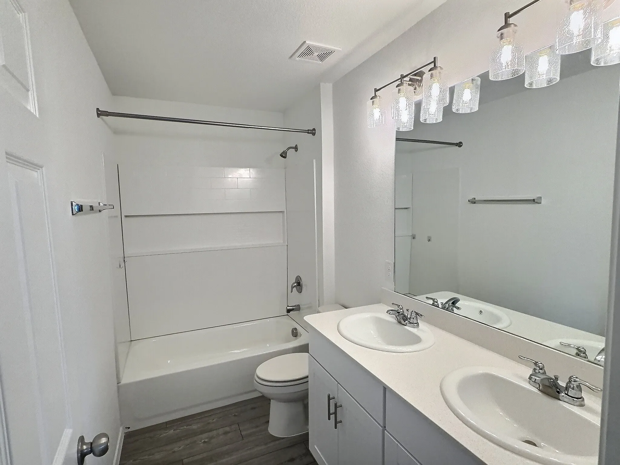 Upstairs secondary bathroom with dual sinks and shower/tub combo