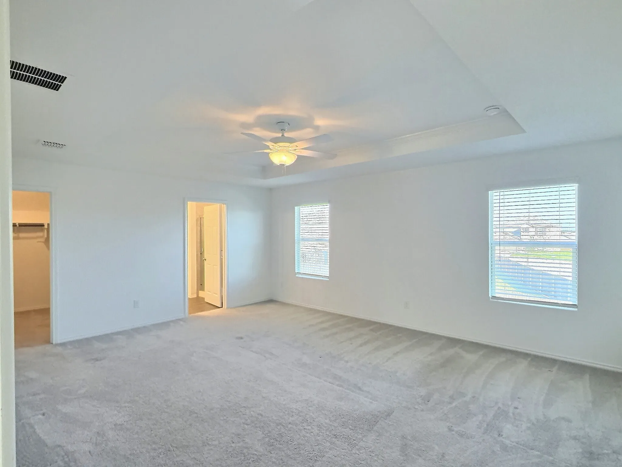 Primary upstairs bedroom with recessed ceiling, ensuite bath and huge closet