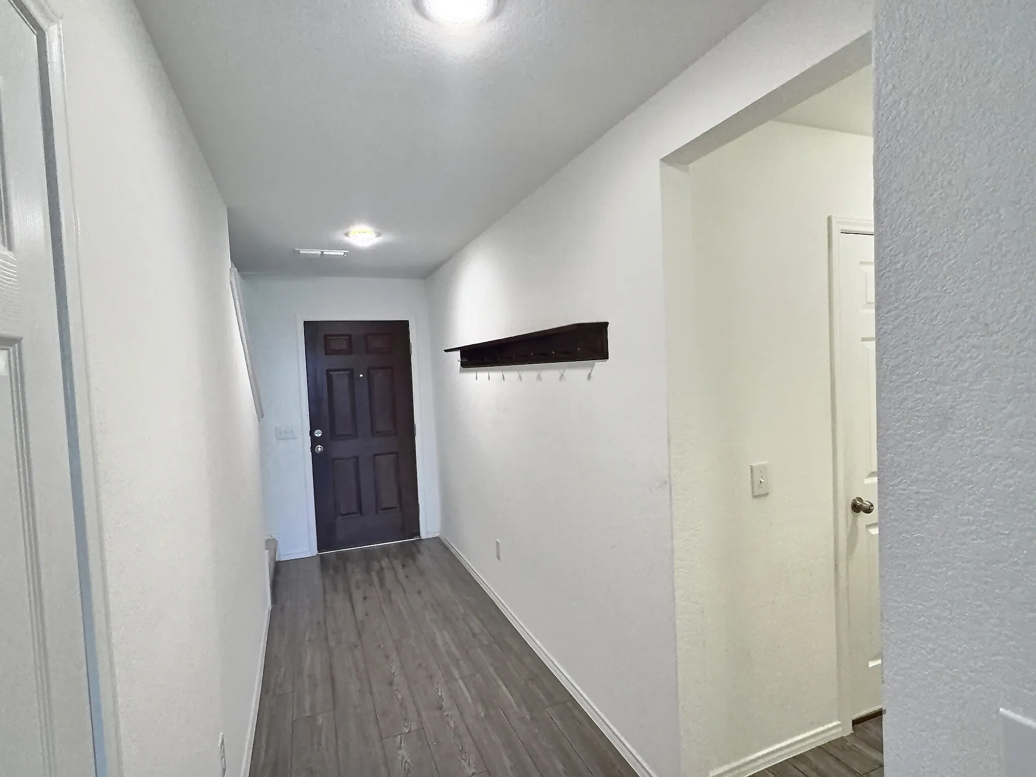 Front entrance next to stairs, with rack for hanging coats