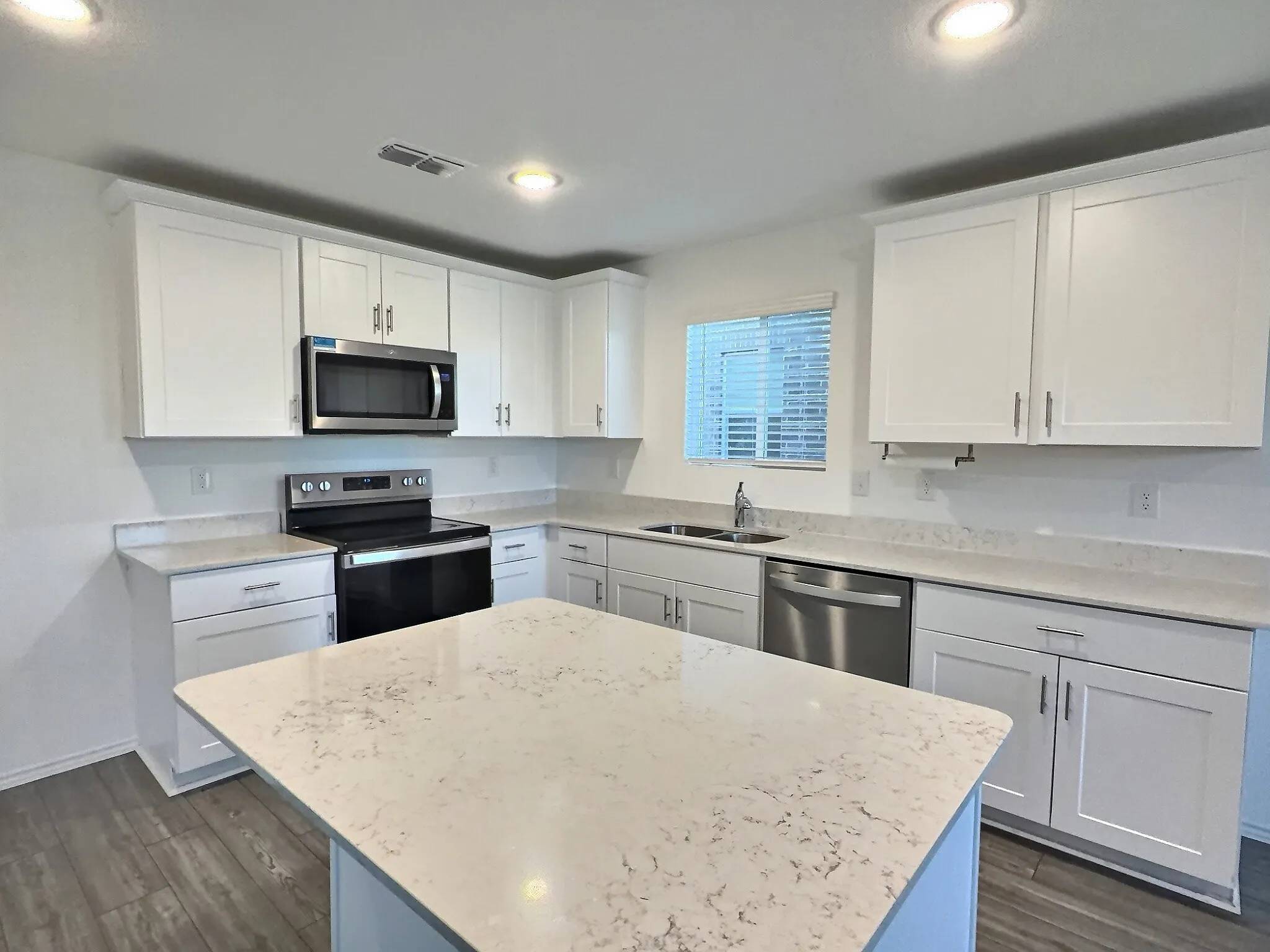 Spacious kitchen with large island open to living room and dining area