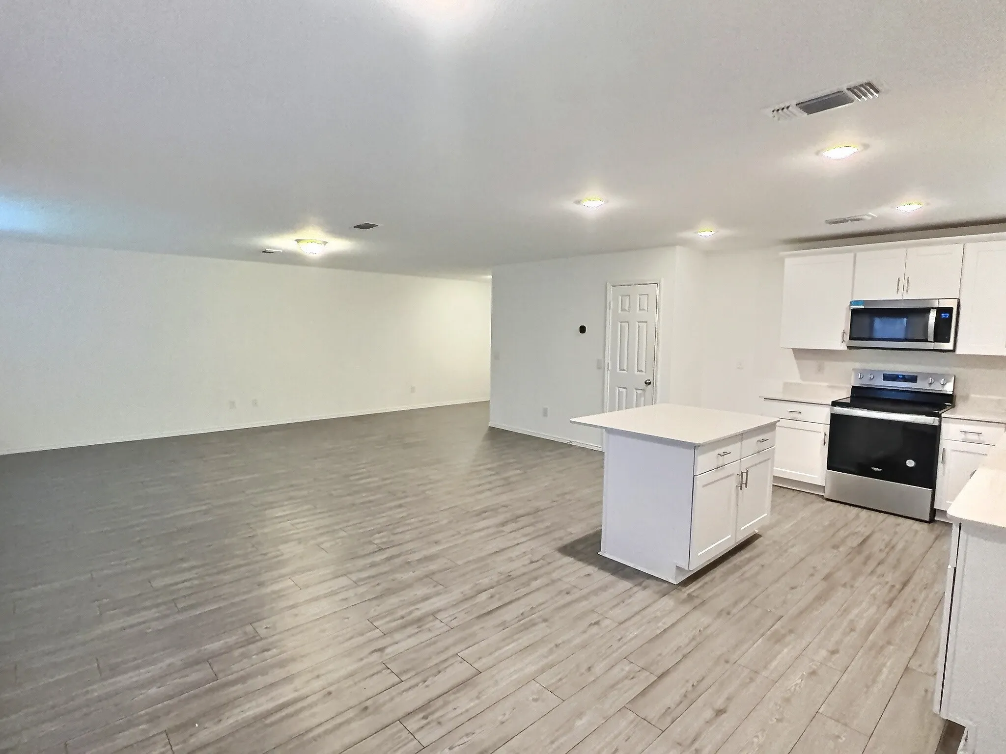 Spacious kitchen with large island open to living room and dining area