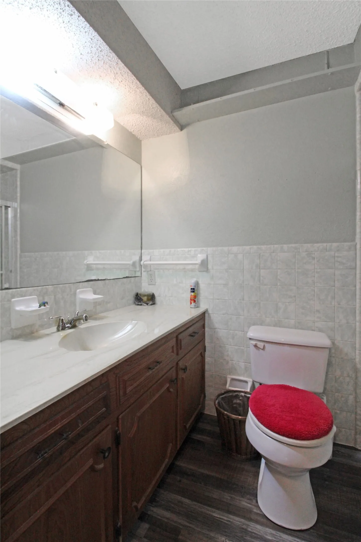 Bathroom featuring a wood-finish vanity with an integrated sink and light-colored countertop