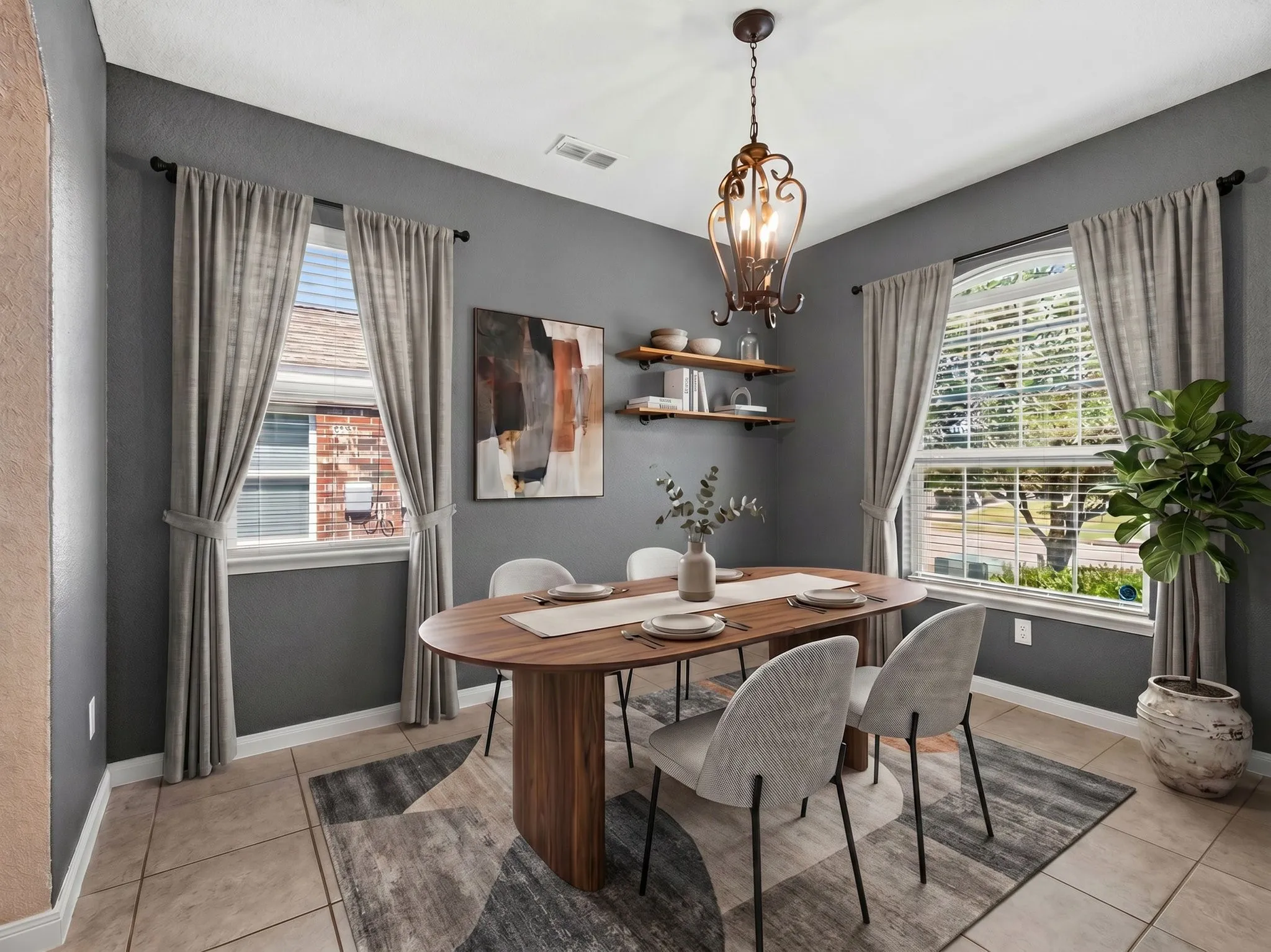 Virtually Staged Formal dining space featuring a decorative chandelier, dual windows with blinds, and tile flooring