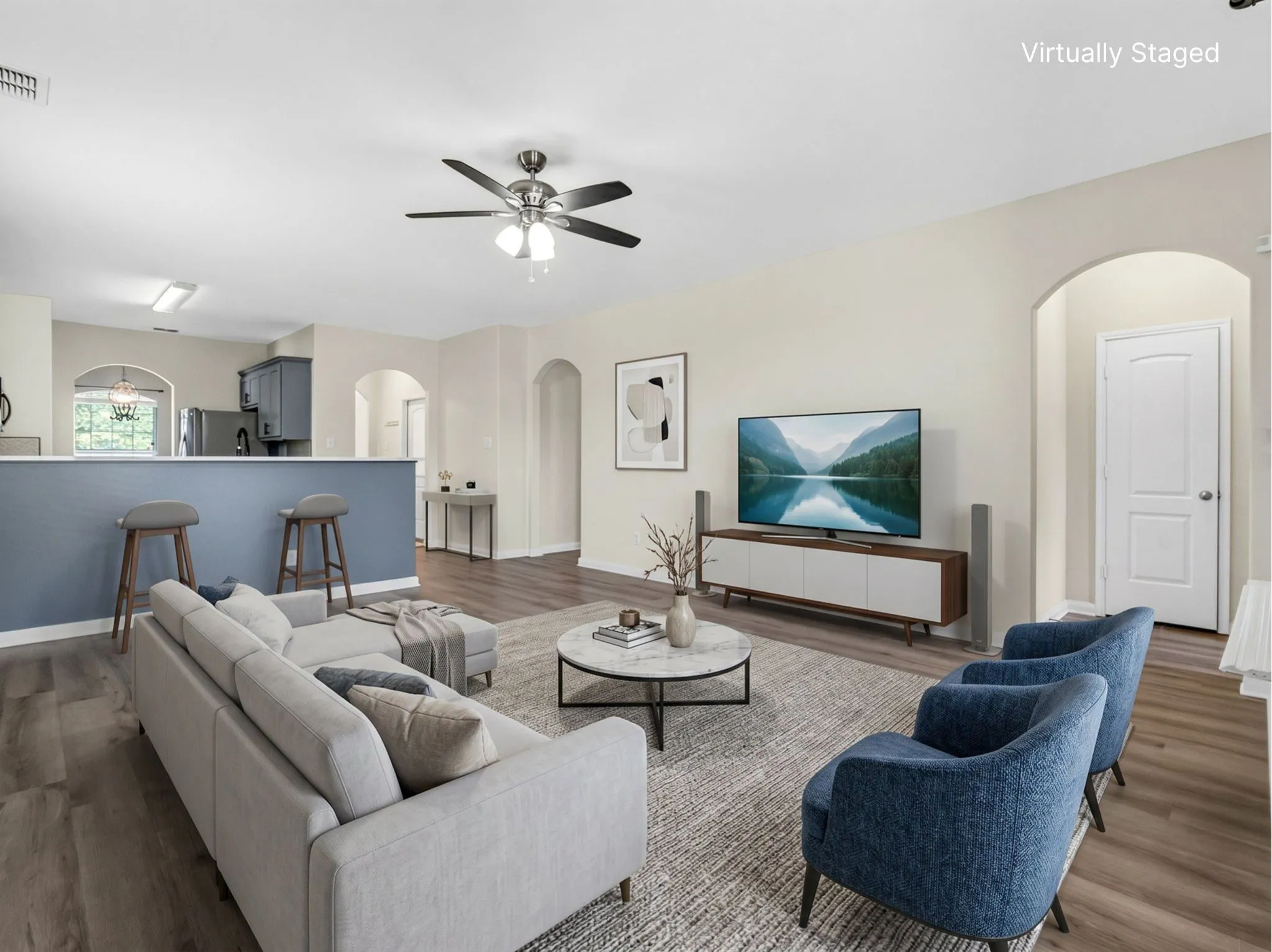 Open-concept living space featuring wood-finish flooring, recessed lighting, and a ceiling fan