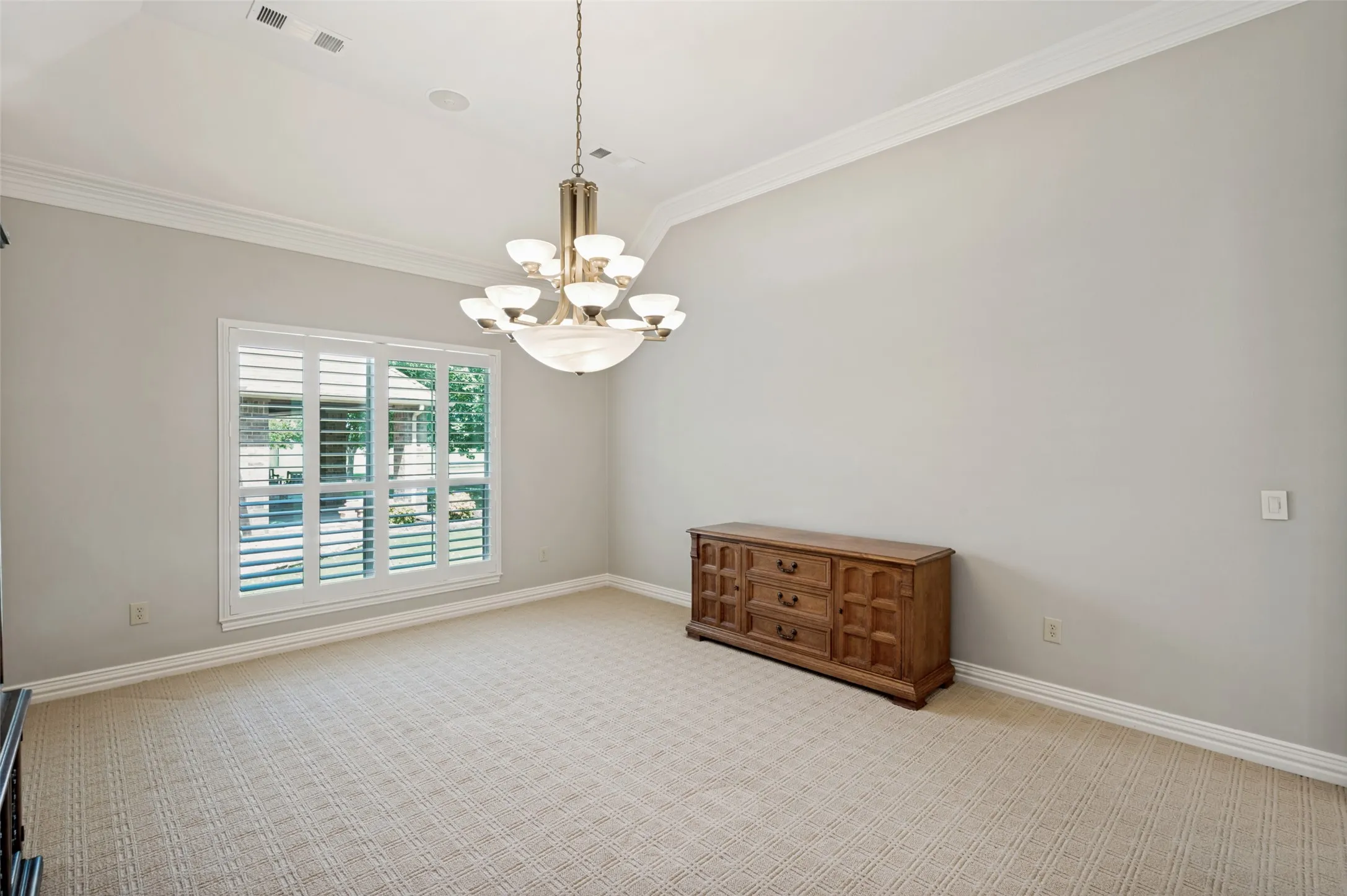 Dining Room with Plantation Shutters and Gorgeous Chandelier.