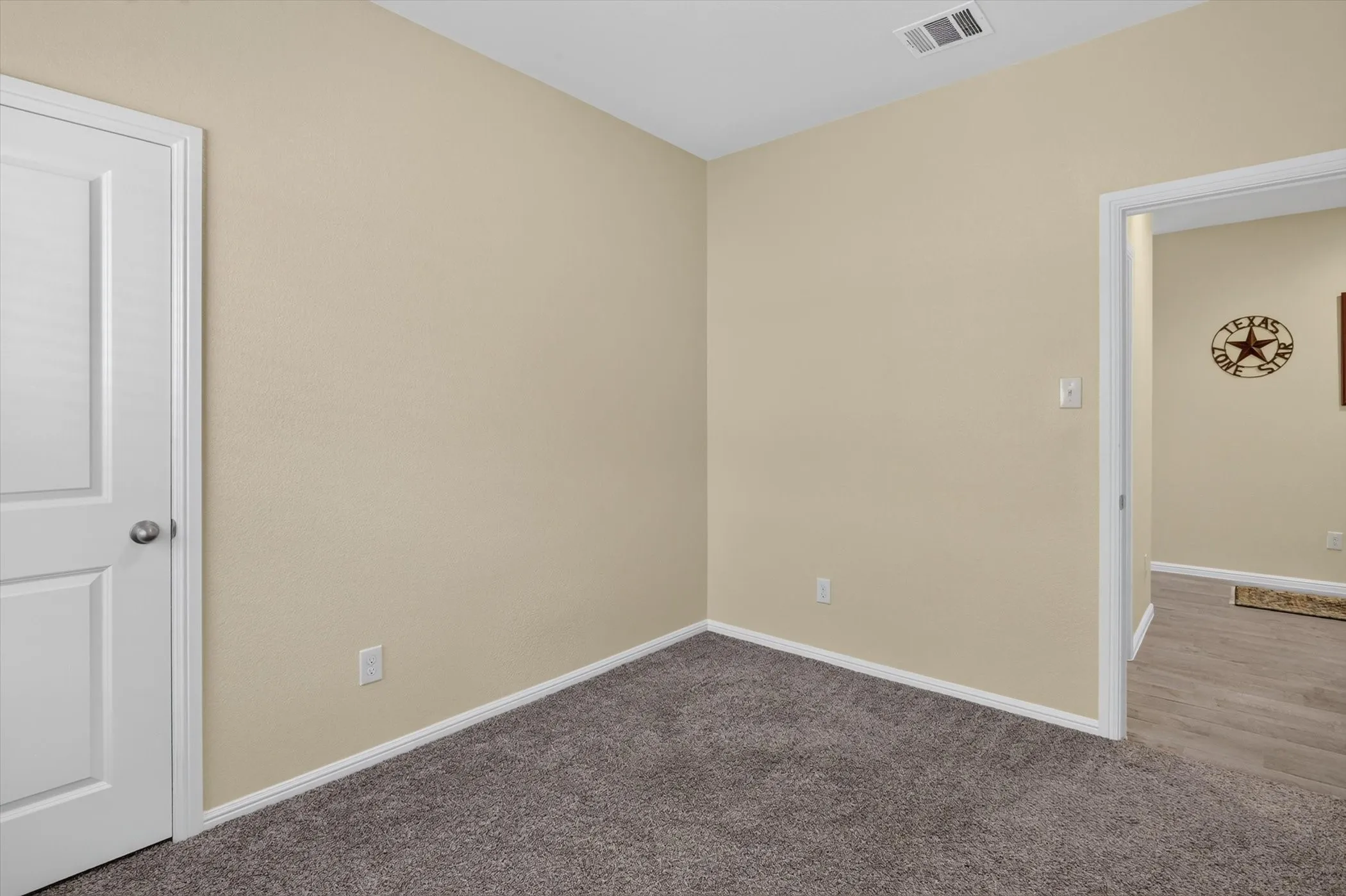 Neutral-toned wall space with textured finish and clean white baseboards