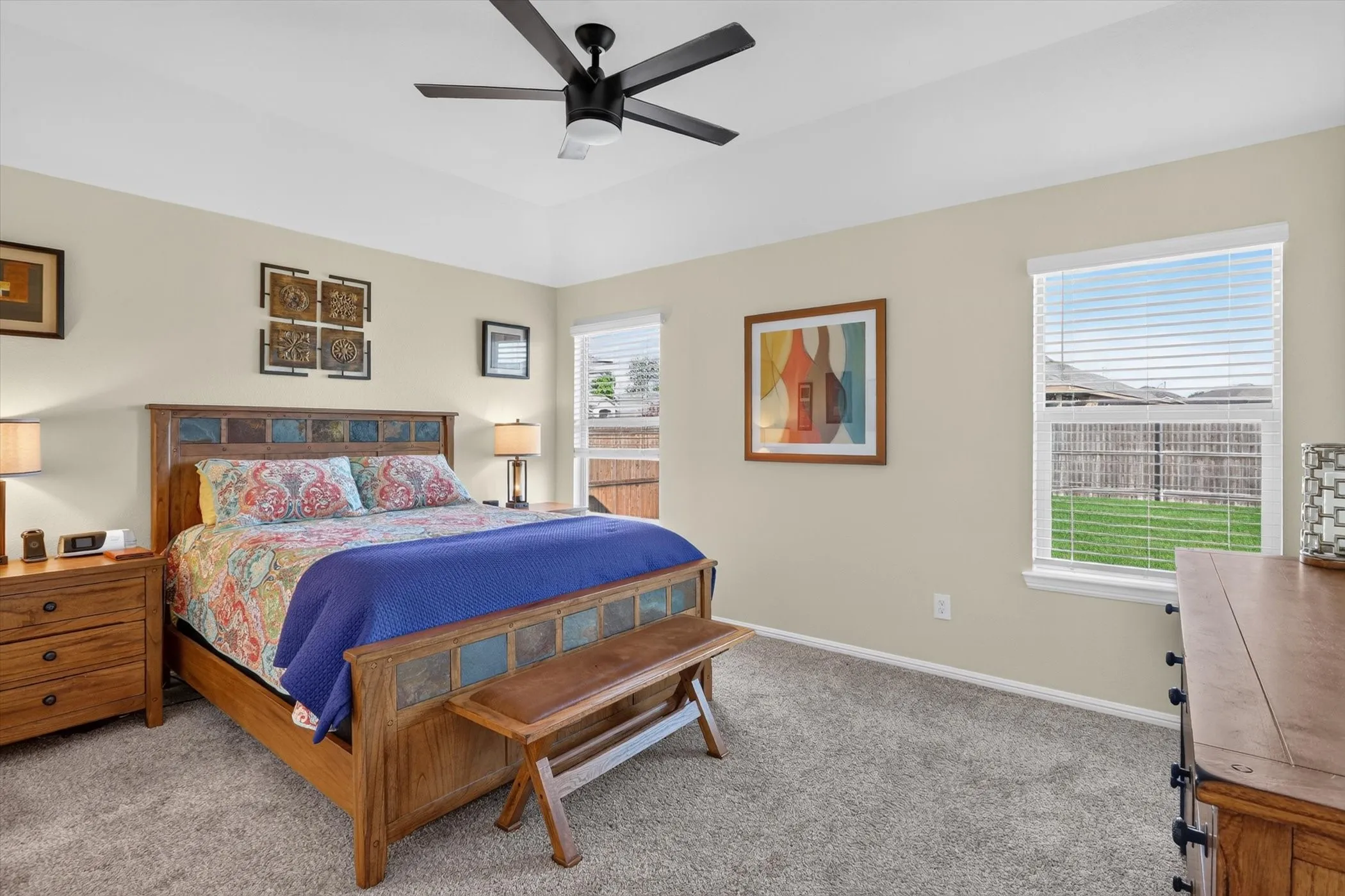 Spacious room featuring vaulted ceilings, a ceiling fan with integrated lighting, neutral-toned walls, and plush carpet flooring