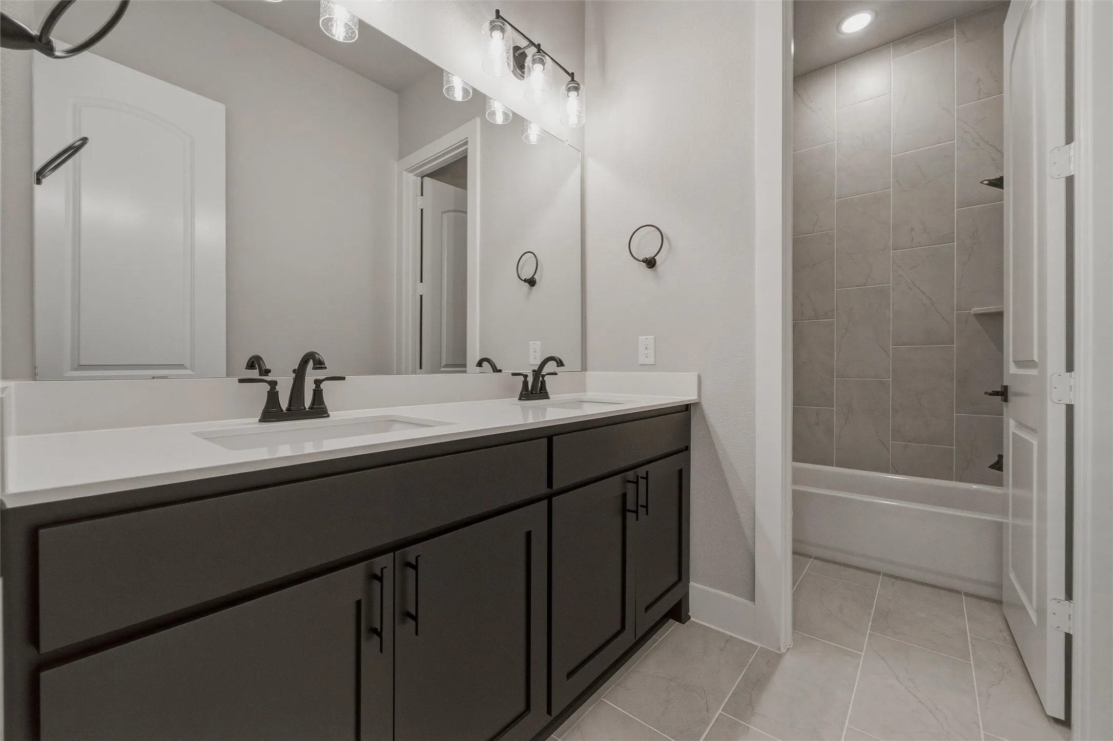 Dual vanity with a white countertop and dark cabinetry