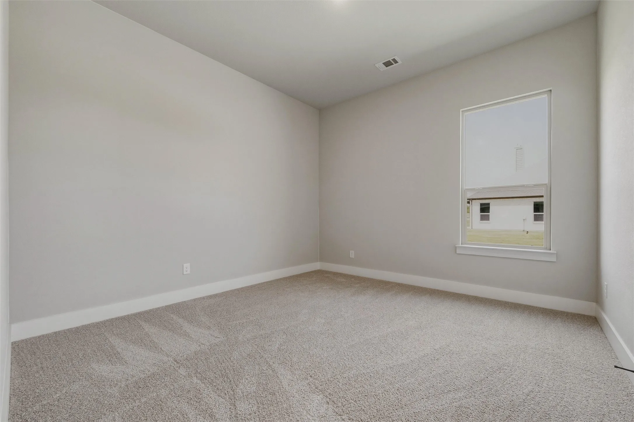 Soft carpeted flooring, neutral wall tones, white trim, and a window with a white frame